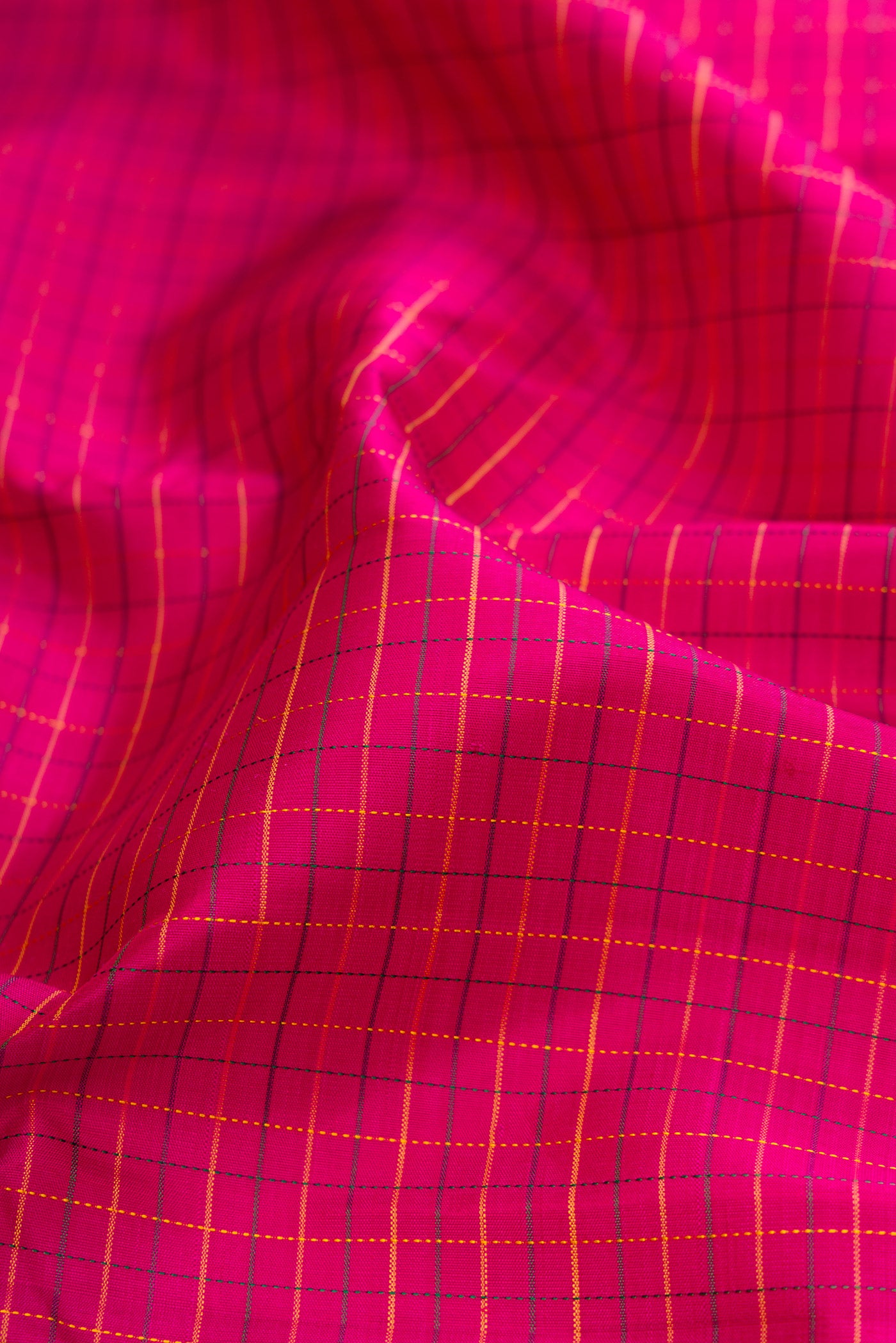 Close up of Magenta Kanchipuram Silk Saree with Checked design on the body and Zari Border.  displaying folds