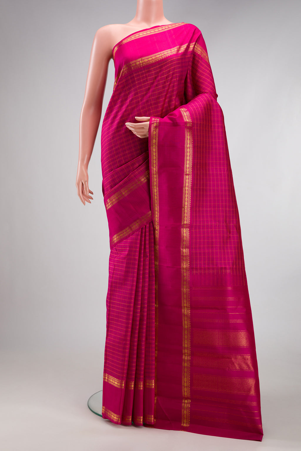 Magenta Kanchipuram Silk Saree with Checked design on the body and Zari Border.  displayed on a mannequin