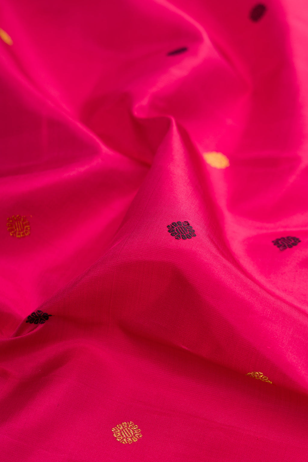 Close up of Dark Pink Kanjivaram Silk Saree with Zari And Thread Butta on the body and Zari Border.  displaying folds