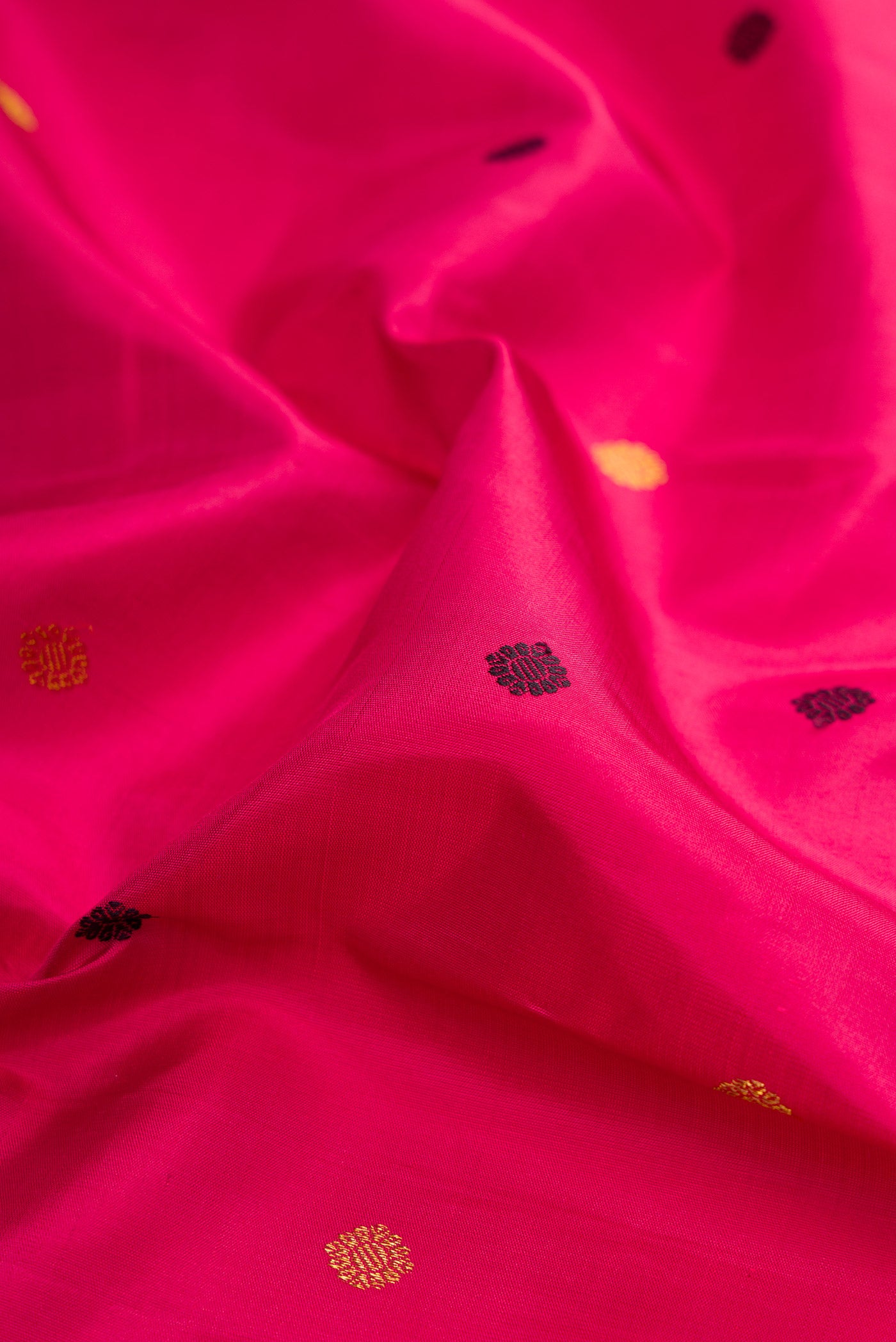Close up of Dark Pink Kanjivaram Silk Saree with Zari And Thread Butta on the body and Zari Border.  displaying folds