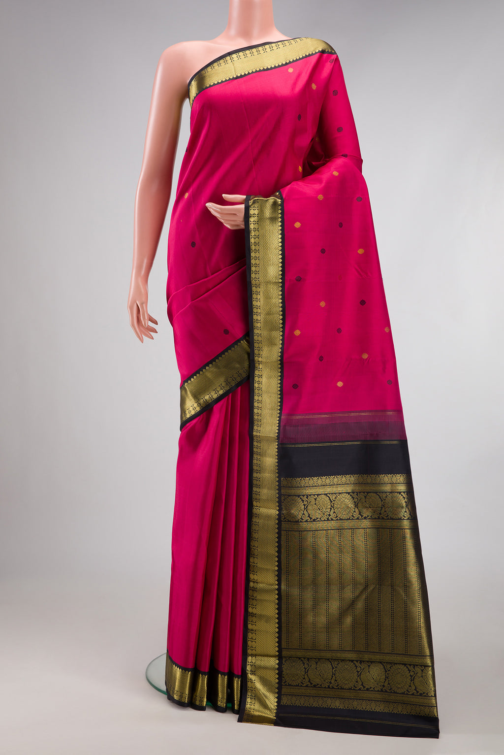Dark Pink Kanjivaram Silk Saree with Zari And Thread Butta on the body and Zari Border.  displayed on a mannequin