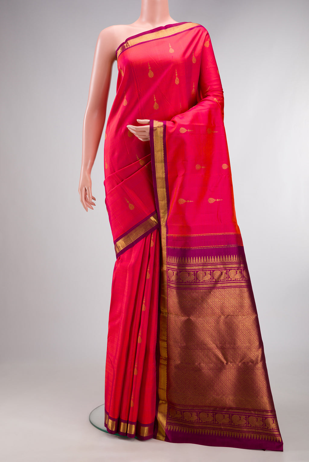 Pure Silk Coral Dual Tone Kanchipuram Saree with Zari Butta on the body and Zari Border.  displayed on a mannequin