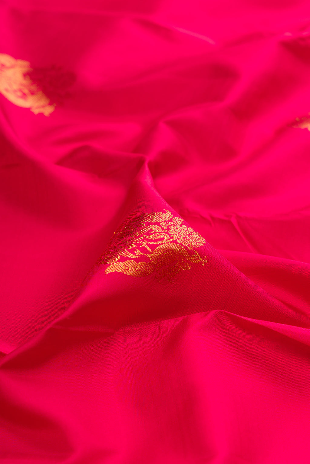 Close up of Dark Pink Kanjivaram Silk Saree with Zari Butta on the body and Fancy Border.  displaying folds