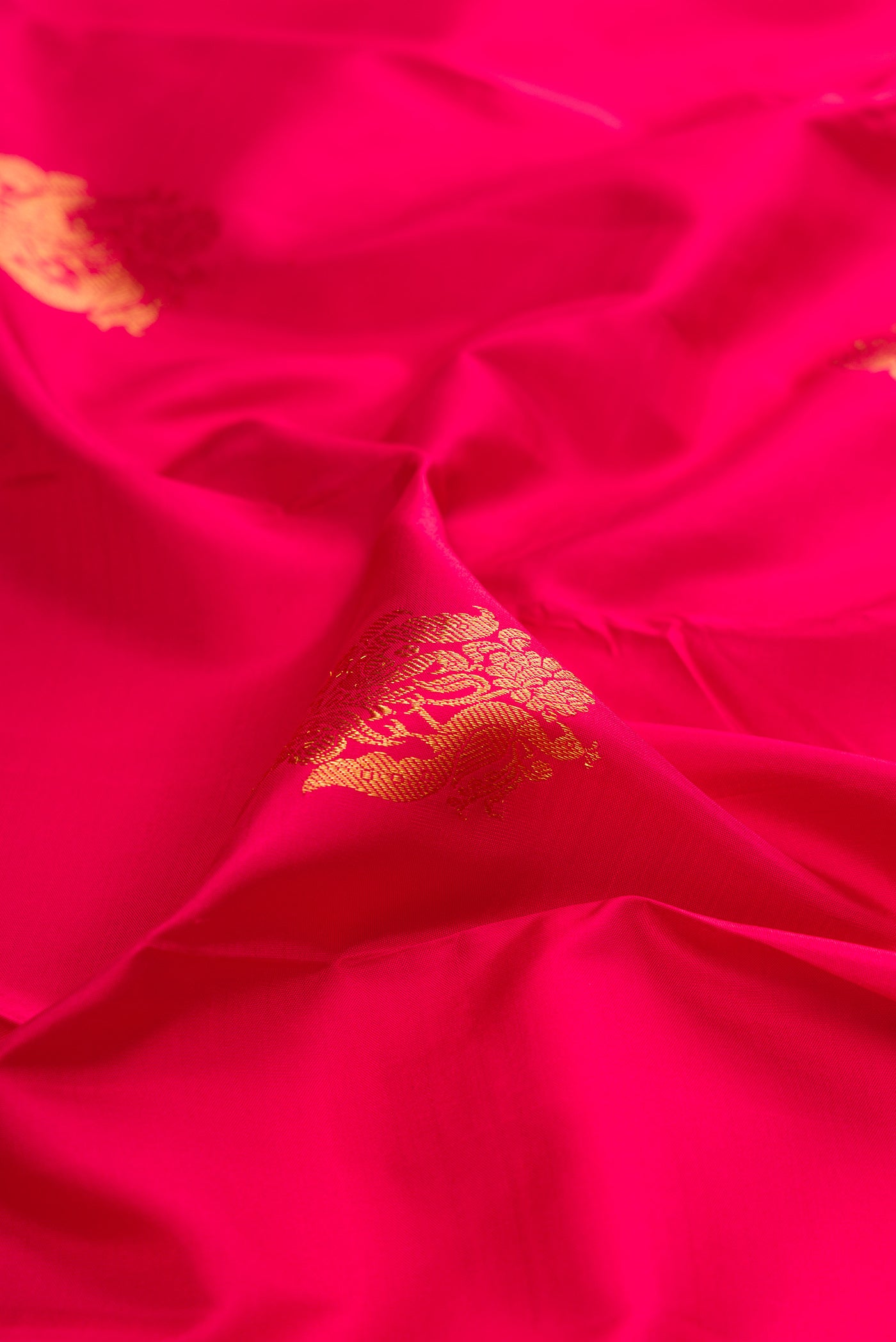 Close up of Dark Pink Kanjivaram Silk Saree with Zari Butta on the body and Fancy Border.  displaying folds