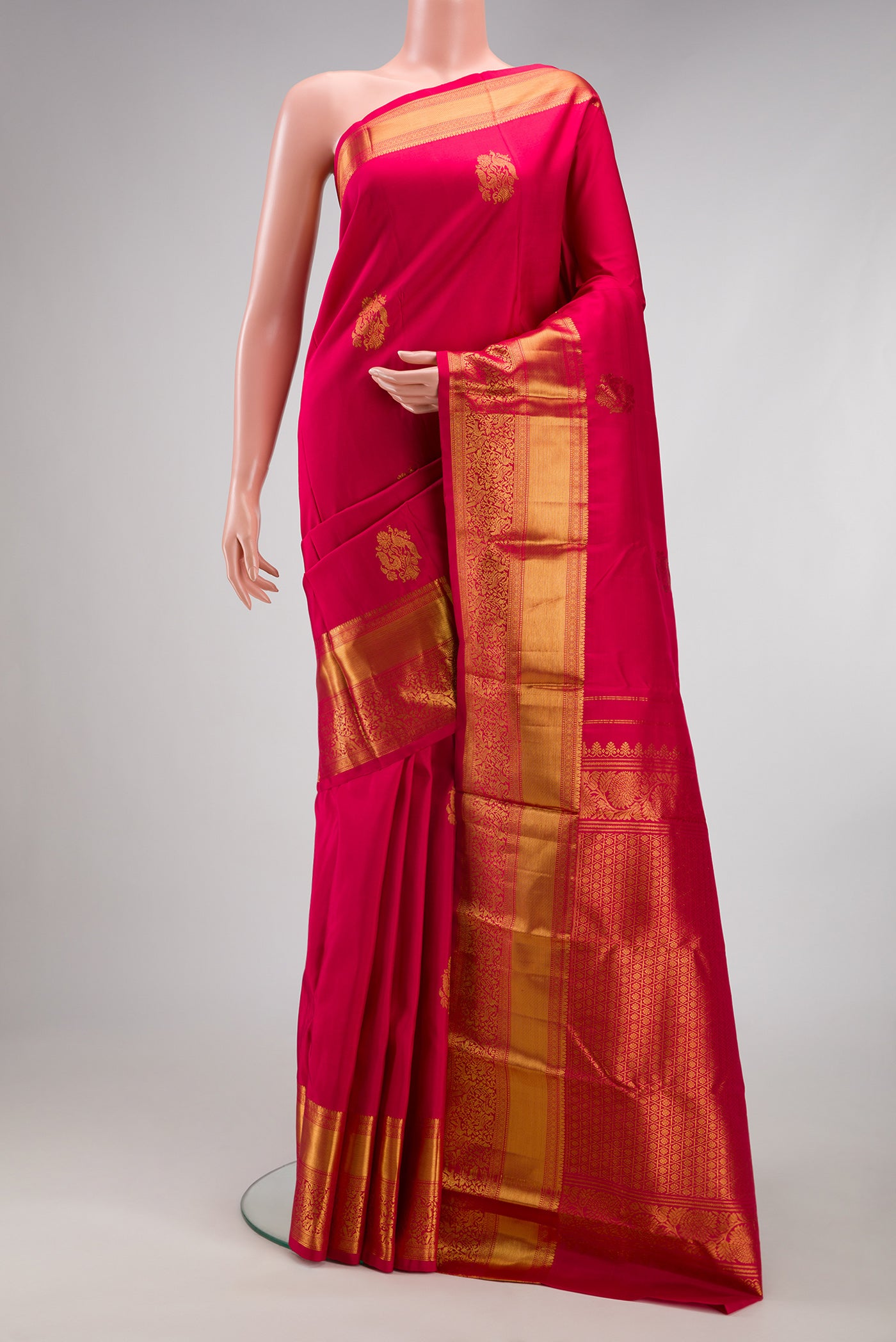 Dark Pink Kanjivaram Silk Saree with Zari Butta on the body and Fancy Border.  displayed on a mannequin