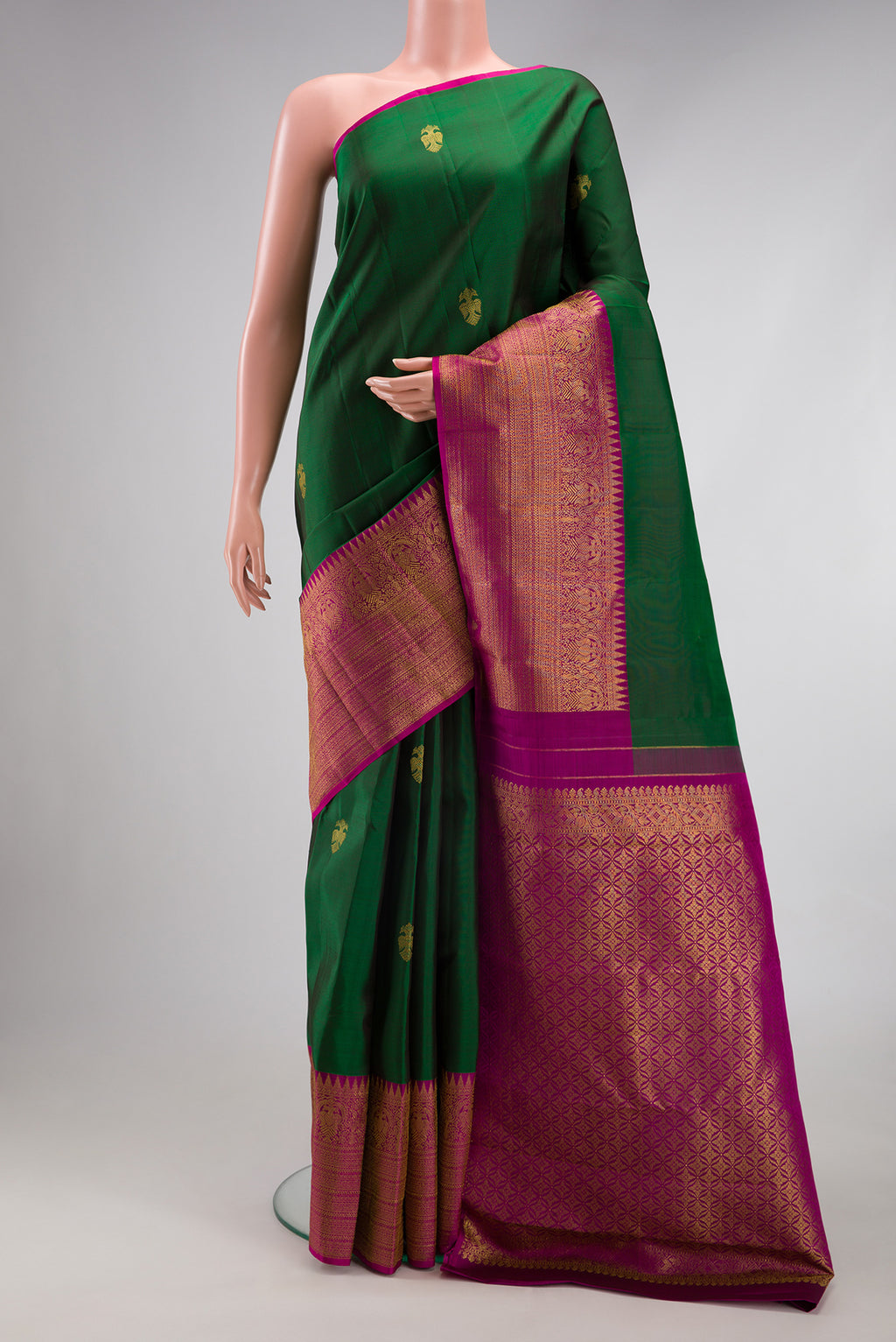 Bottle Green Kanjivaram Silk Saree with Zari Butta on the body and Fancy Border.  displayed on a mannequin