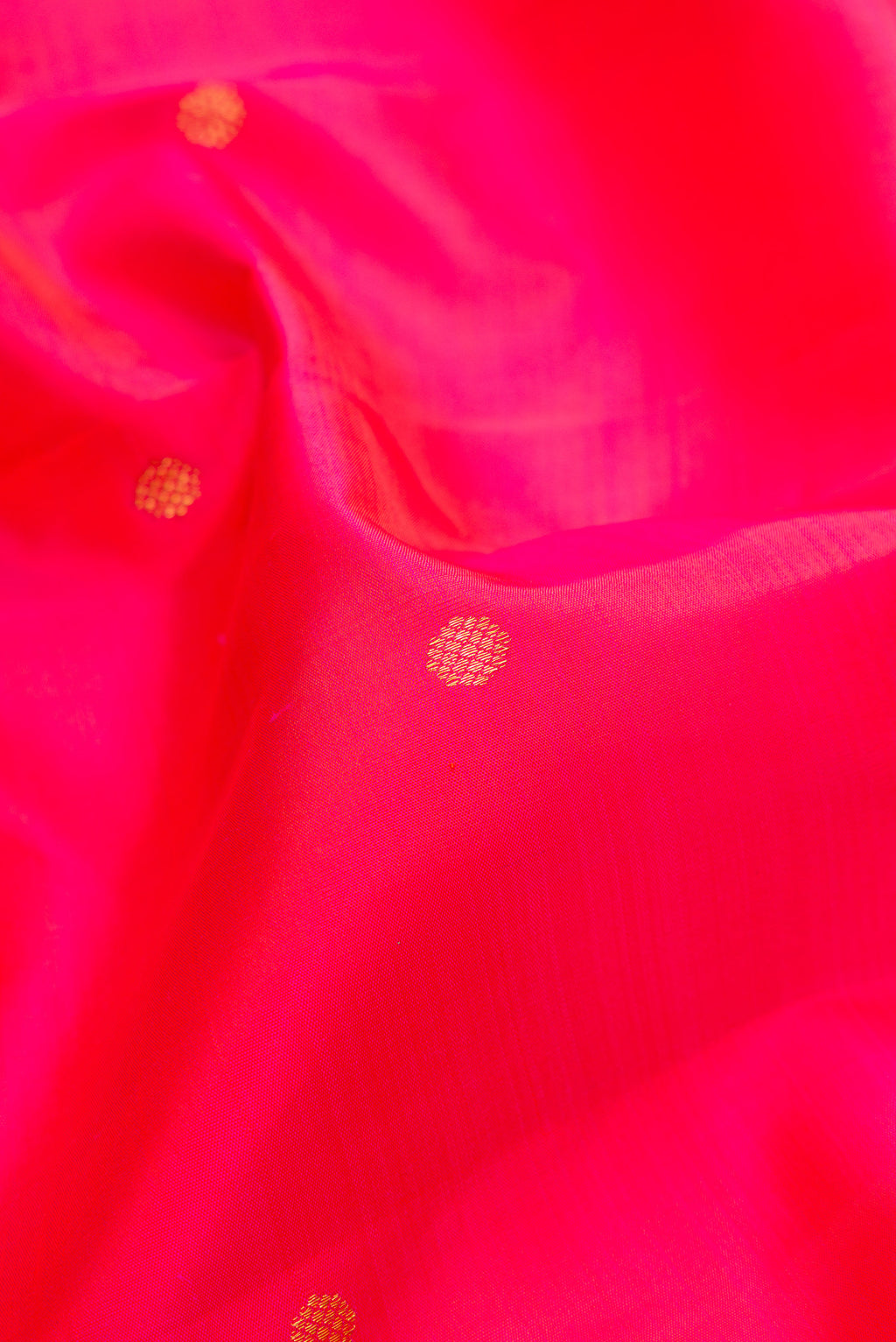 Close up of Pink Kanjivaram Silk Saree with Zari Butta on the body and Zari Border.  displaying folds