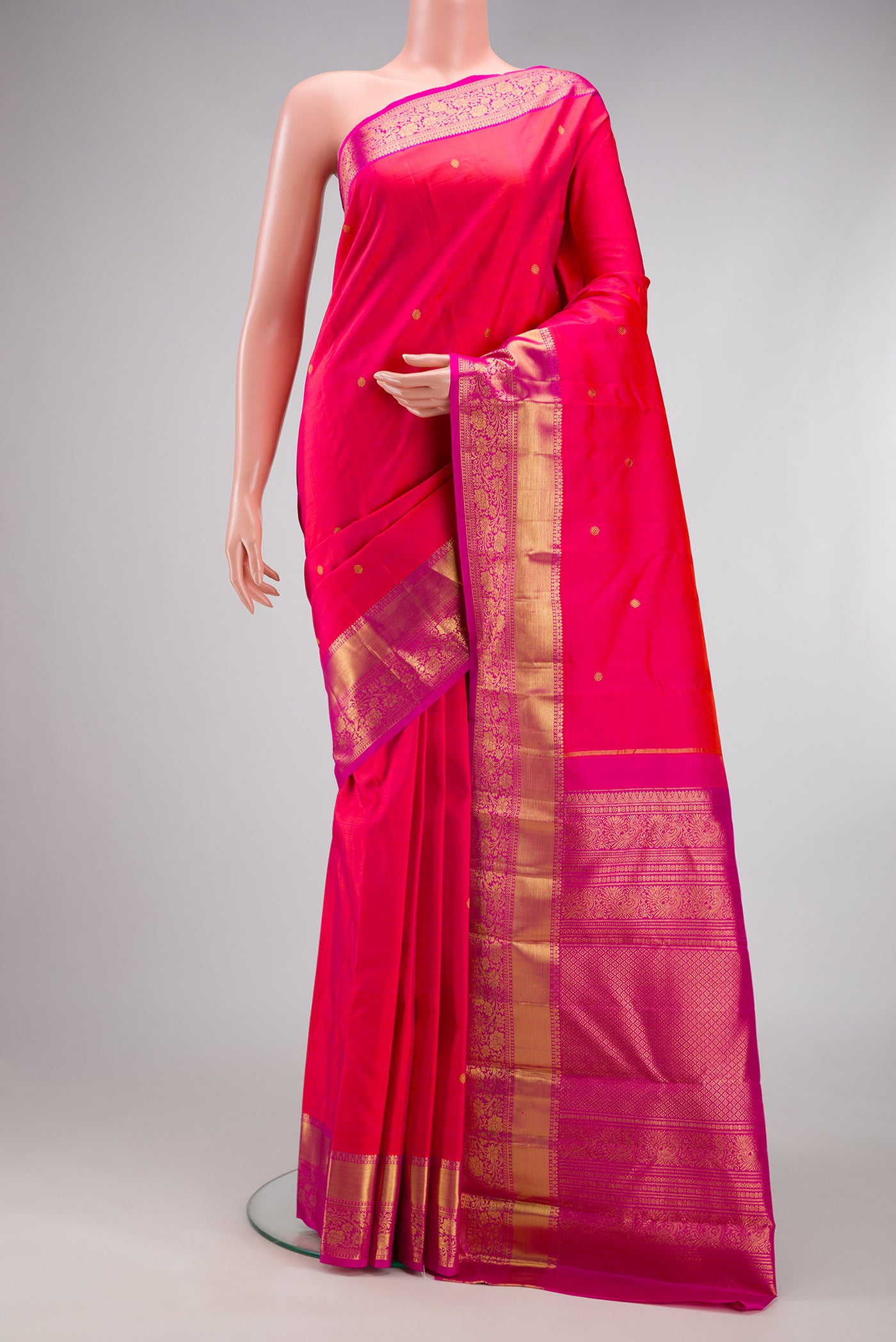 Pink Kanjivaram Silk Saree with Zari Butta on the body and Zari Border.  displayed on a mannequin