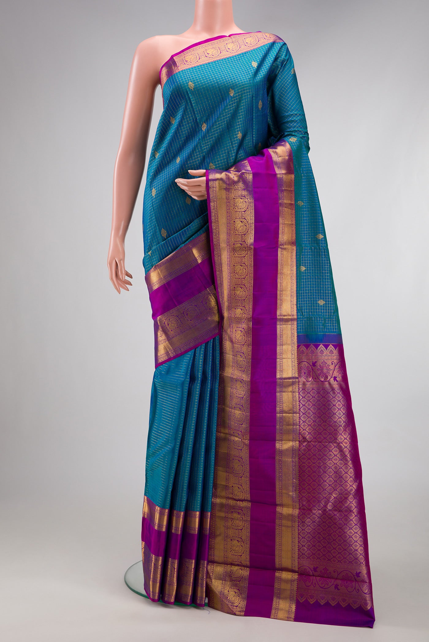 Peacock Blue Dual Tone Kanjivaram Silk Saree with Checked design on the body and Fancy Border.  displayed on a mannequin