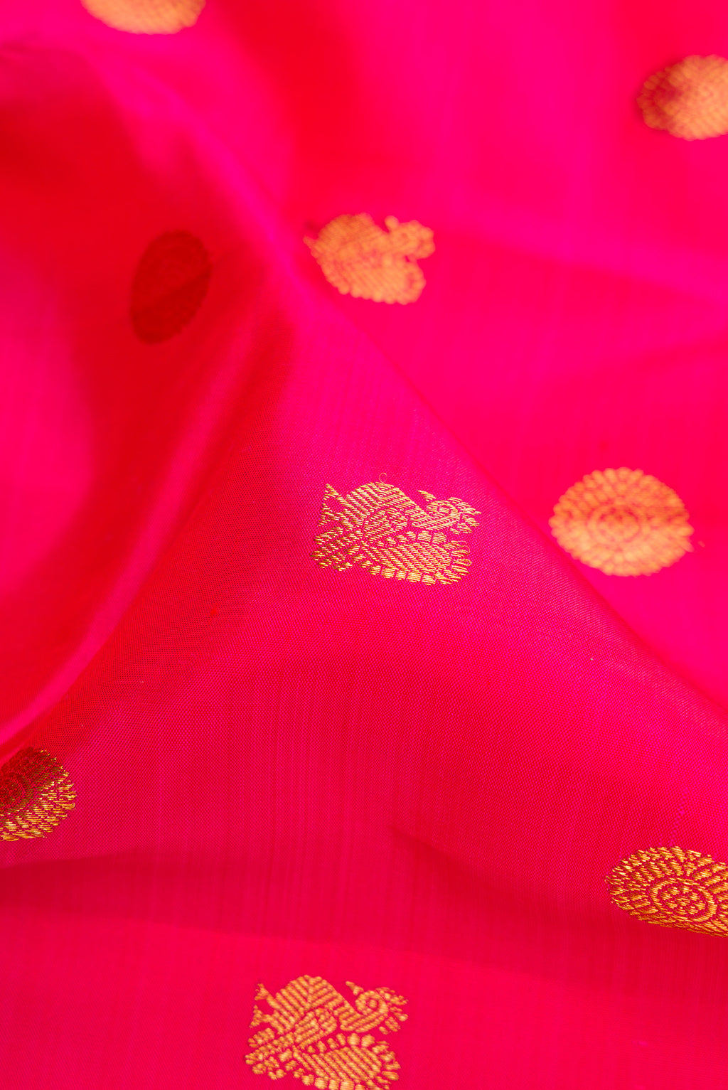 Close up of Dark Pink Kanjivaram Silk Saree with Zari Butta on the body and Zari Border.  displaying folds