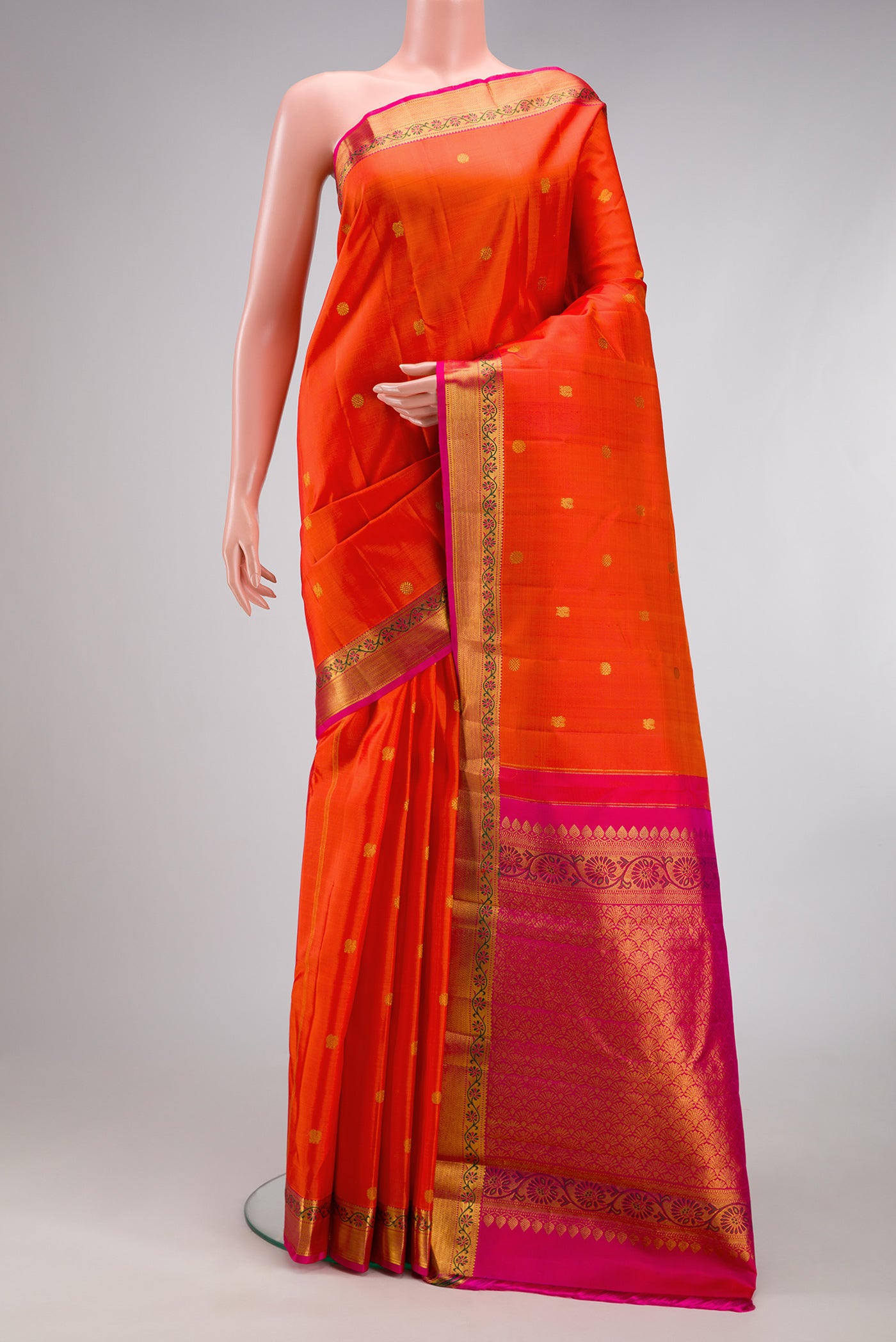 Orange Kanjivaram Silk Saree with Zari Butta on the body and Zari And Thread Border.  displayed on a mannequin
