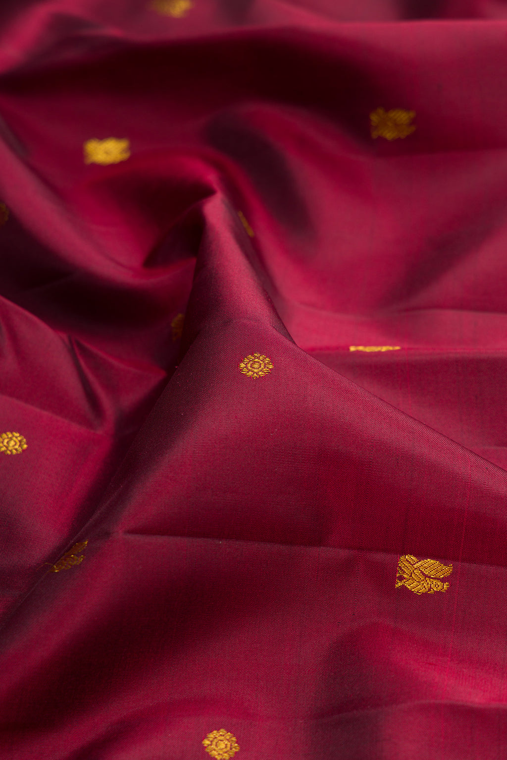 Close up of Maroon Kanjivaram Silk Saree with Zari Butta on the body and Zari Border.  displaying folds
