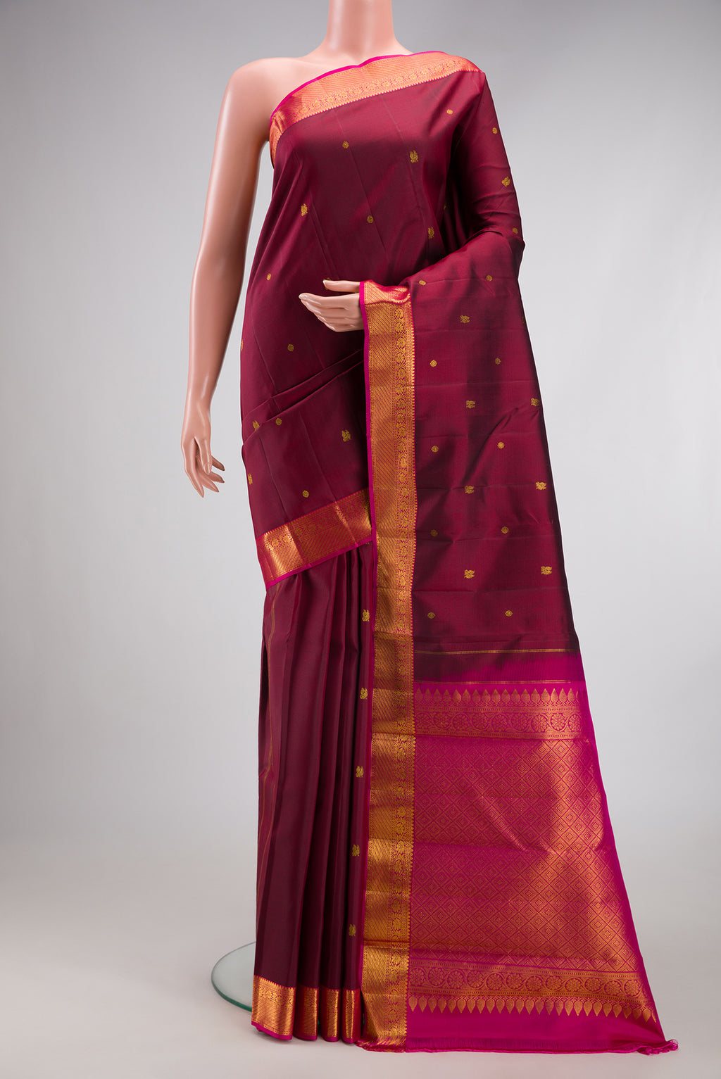 Maroon Kanjivaram Silk Saree with Zari Butta on the body and Zari Border.  displayed on a mannequin