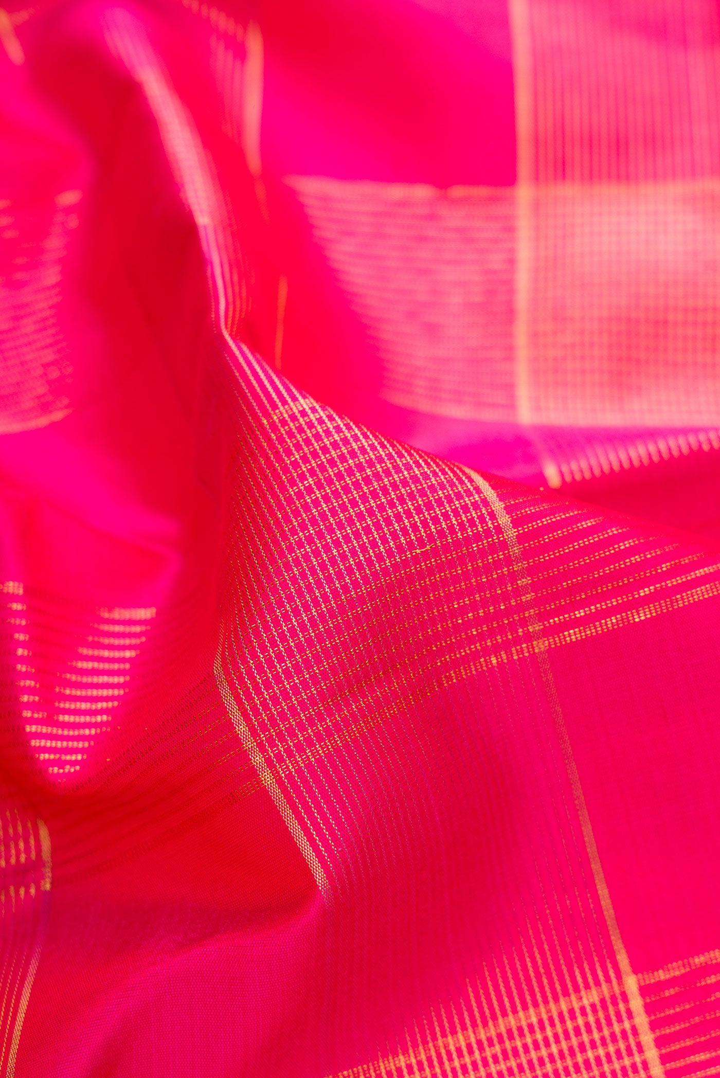 Close up of Pink Kanjivaram Silk Saree with Checked design on the body and Zari Border.  displaying folds
