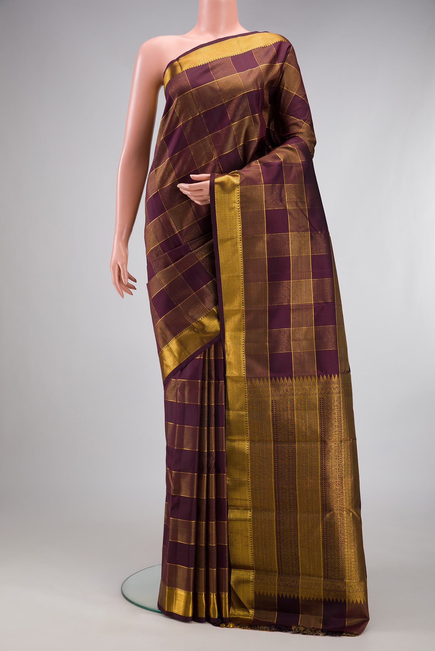 Burgundy Kanjivaram Silk Saree with Checked design on the body and Zari Border.  displayed on a mannequin