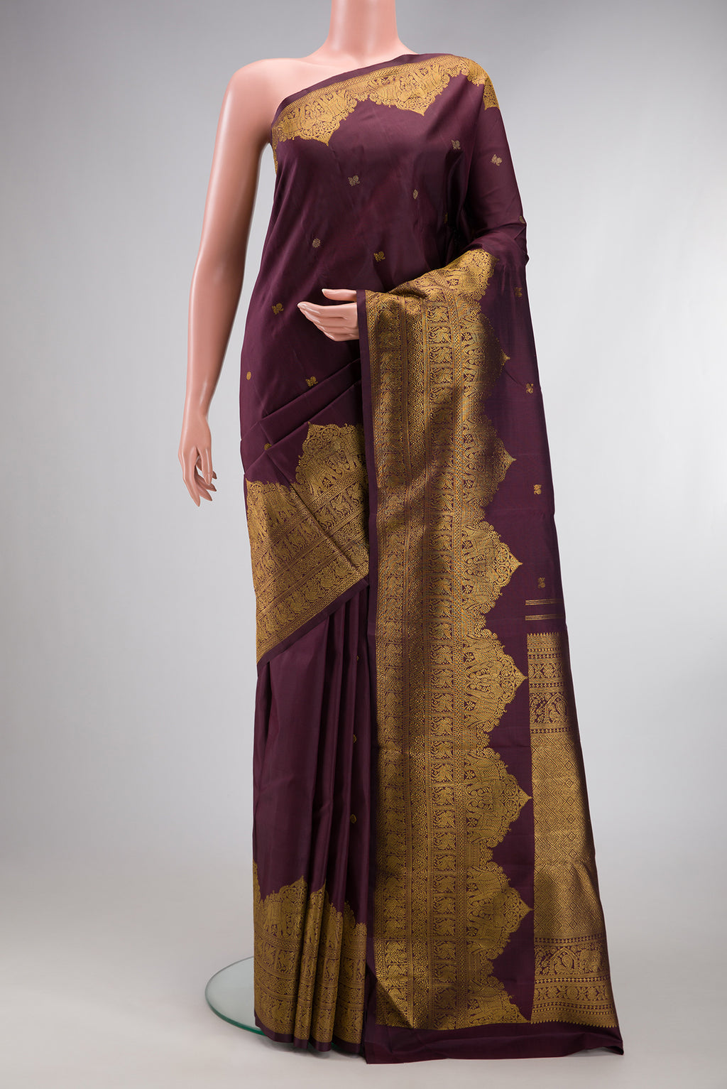 Burgundy Kanjivaram Silk Saree with Zari Butta on the body and Fancy Border.  displayed on a mannequin