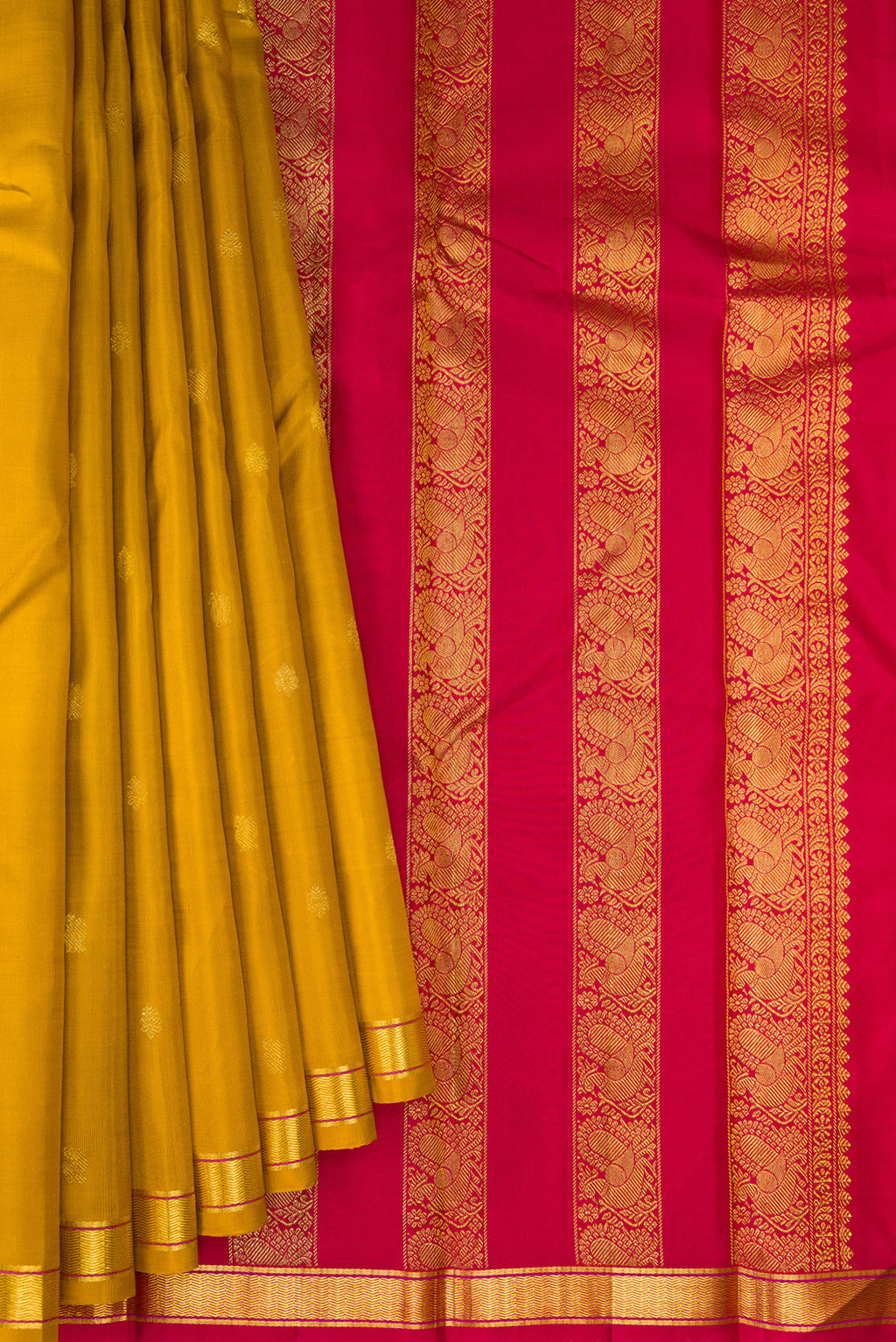 Pleats and pallu of Mustard Kanchipuram Silk Saree with Zari Butta on the body and Zari Border. 