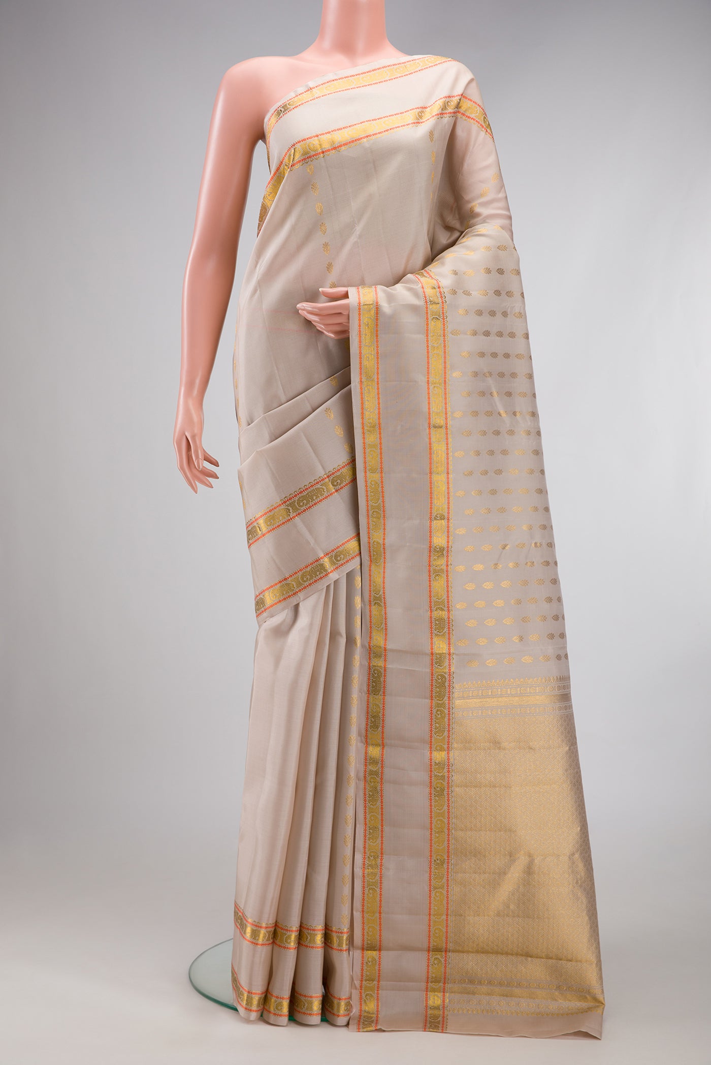 Dark Beige Kanjivaram Silk Saree with Zari Butta on the body and Zari And Thread Border.  displayed on a mannequin