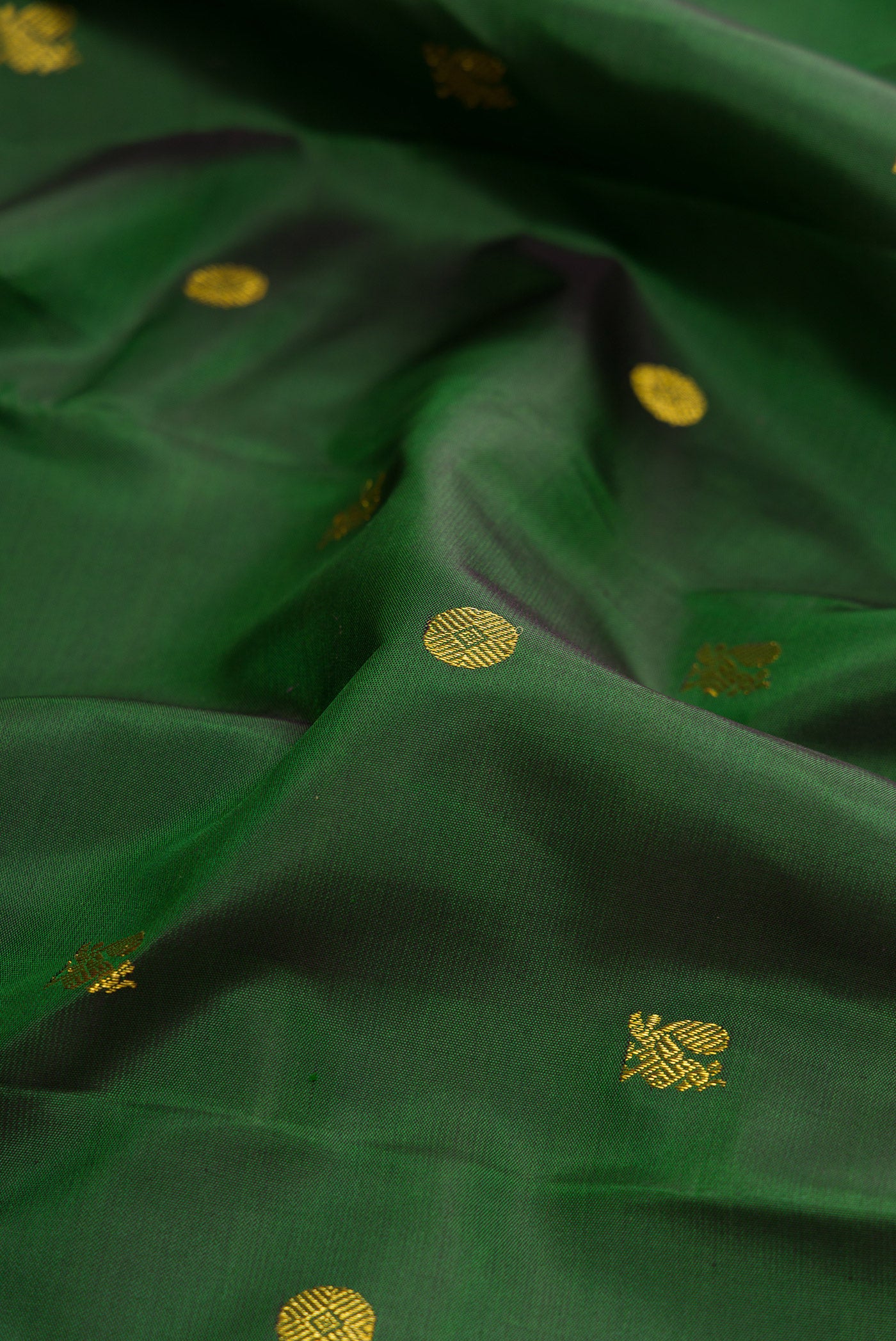 Close up of Green Kanchipuram Silk Saree with Zari Butta on the body and Zari Border.  displaying folds