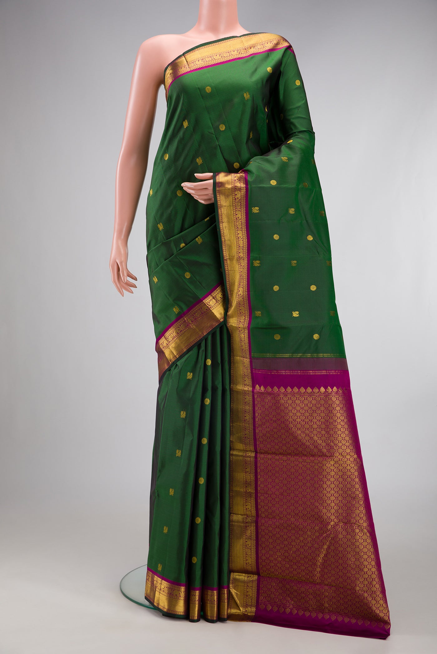Green Kanchipuram Silk Saree with Zari Butta on the body and Zari Border.  displayed on a mannequin