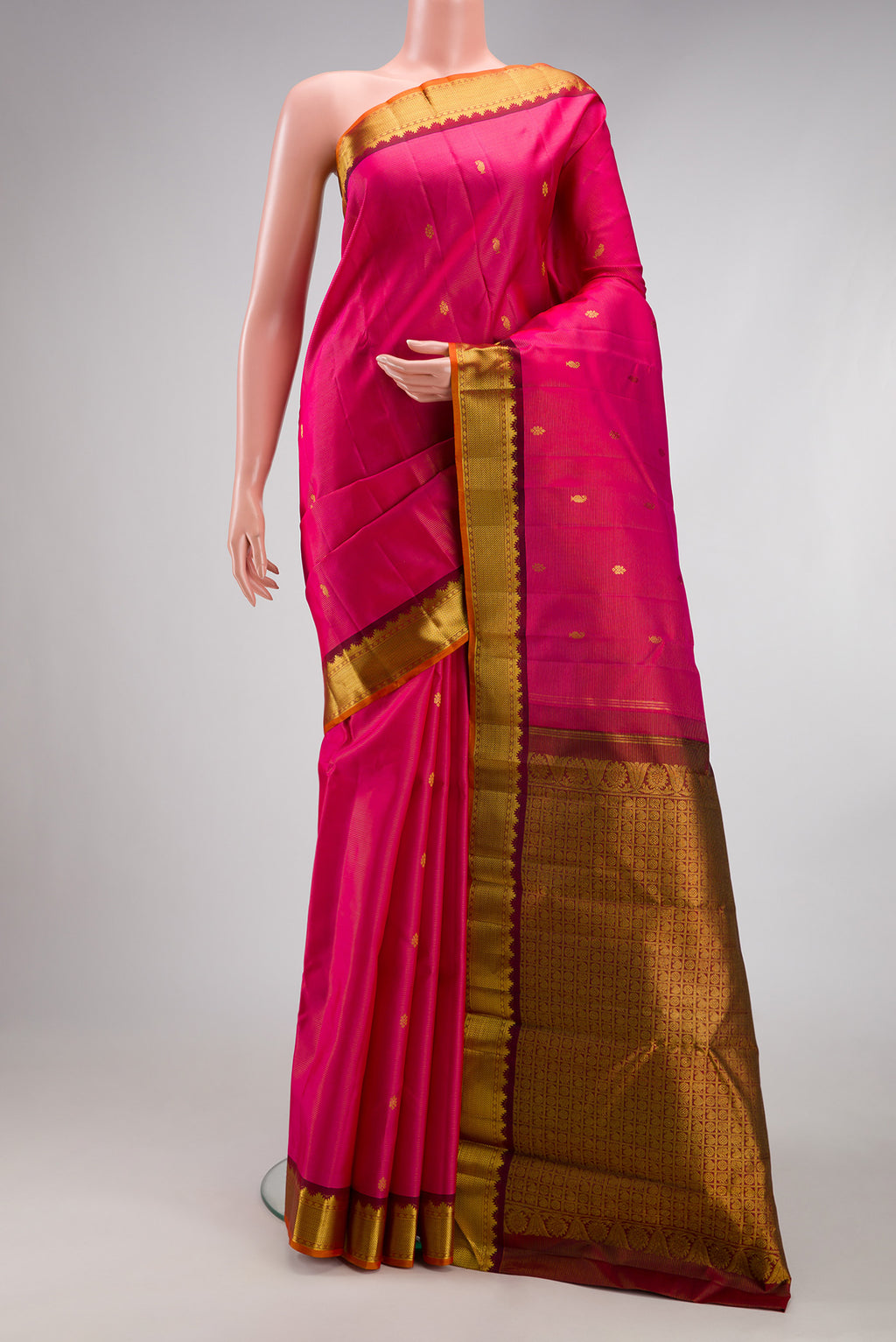Rani Pink Kanjivaram Silk Saree with Zari Butta on the body and Zari Border.  displayed on a mannequin