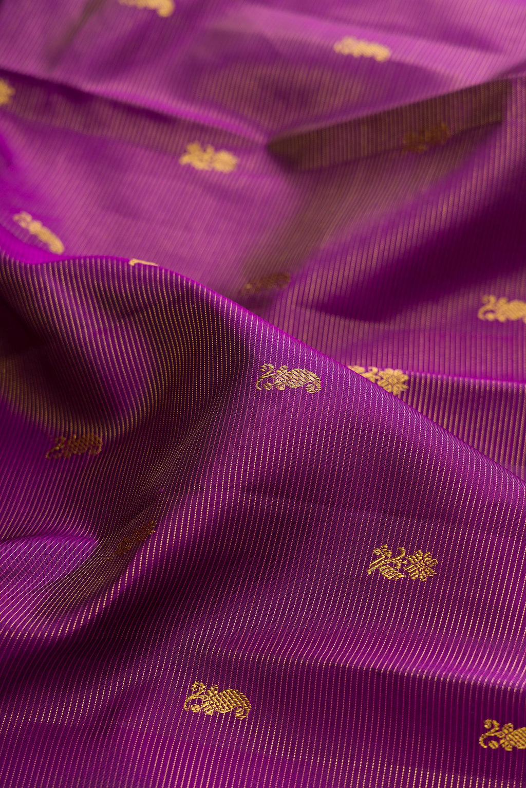 Close up of Purple Kanjivaram Silk Saree with Zari Butta on the body and Zari Border.  displaying folds