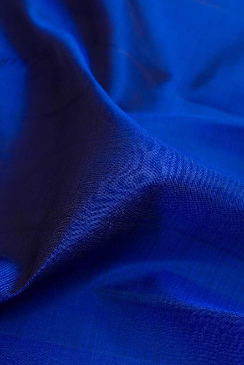 Close up of Royal Blue Kanjivaram Silk Saree with Plain Body and Zari Border.  displaying folds