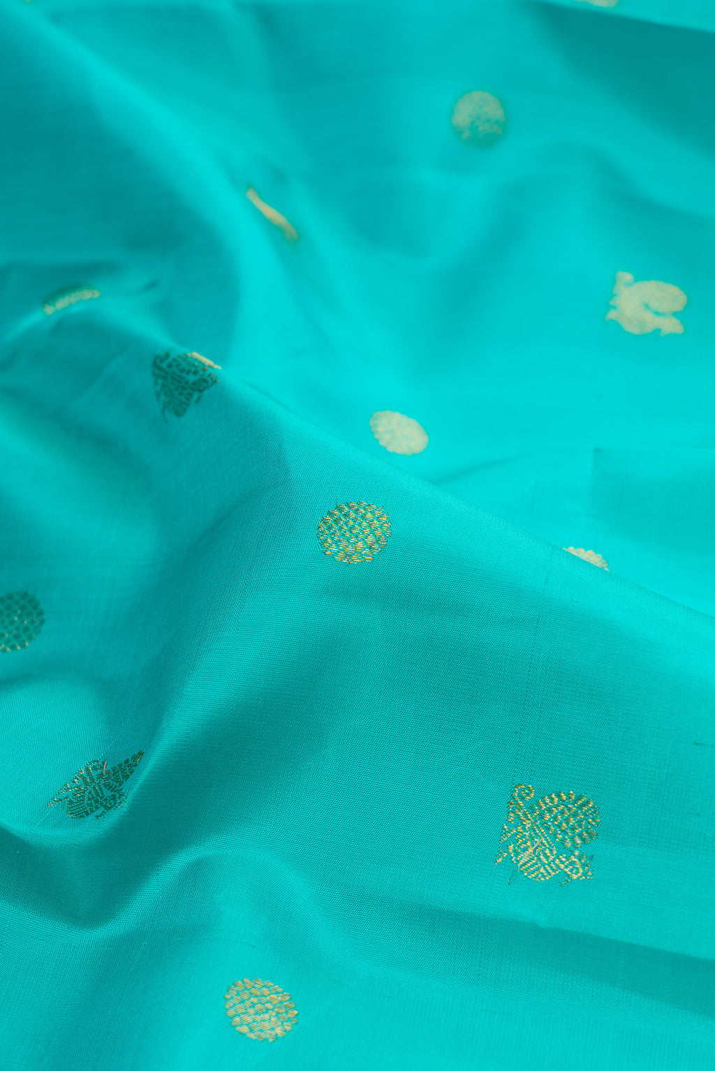 Close up of Pure Silk Sky Blue Kanjivaram Saree with Zari Butta on the body and Zari Border.  displaying folds