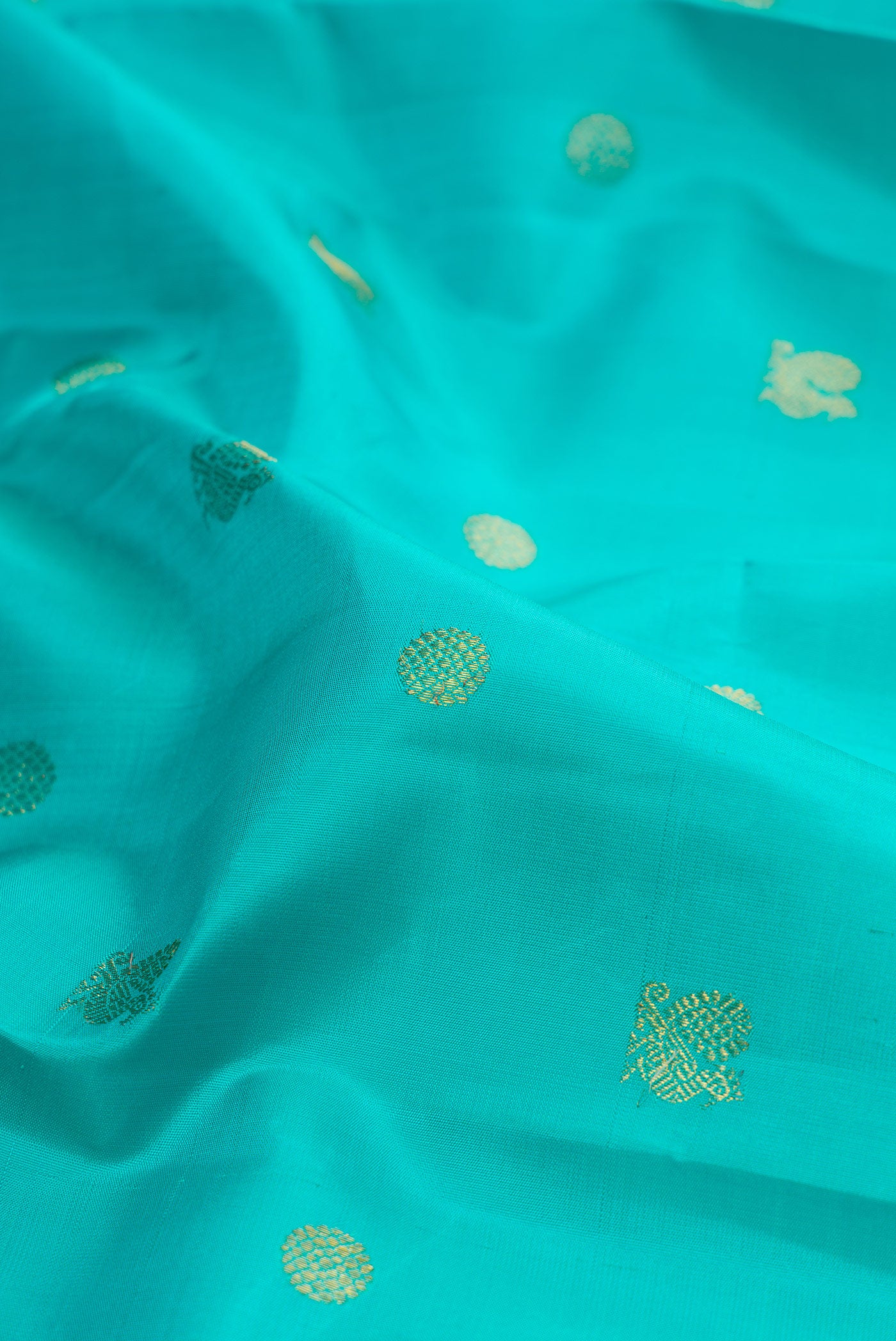 Close up of Pure Silk Sky Blue Kanjivaram Saree with Zari Butta on the body and Zari Border.  displaying folds