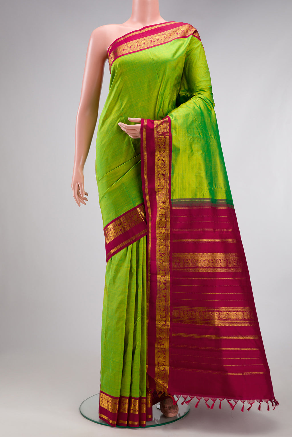 Parrot Green Kanjivaram Silk Saree with Plain Body and Zari Border.  displayed on a mannequin