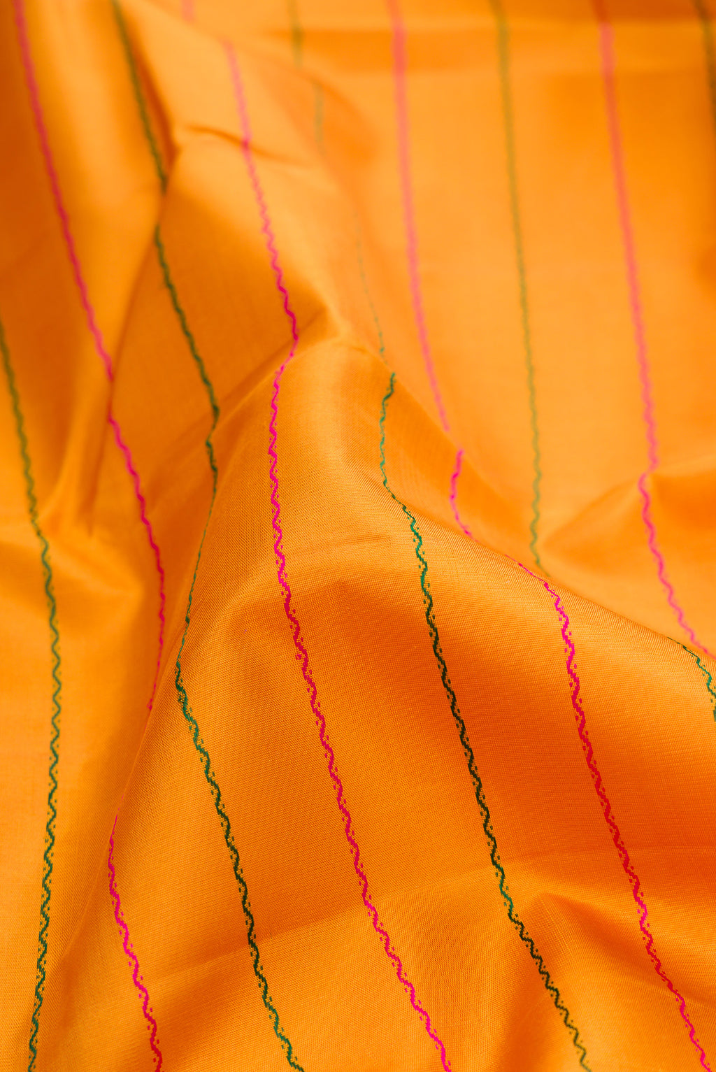 Close up of Mustard Kanchipuram Silk Saree with Veldhari on the body and Ganga Jamuna Border.  displaying folds