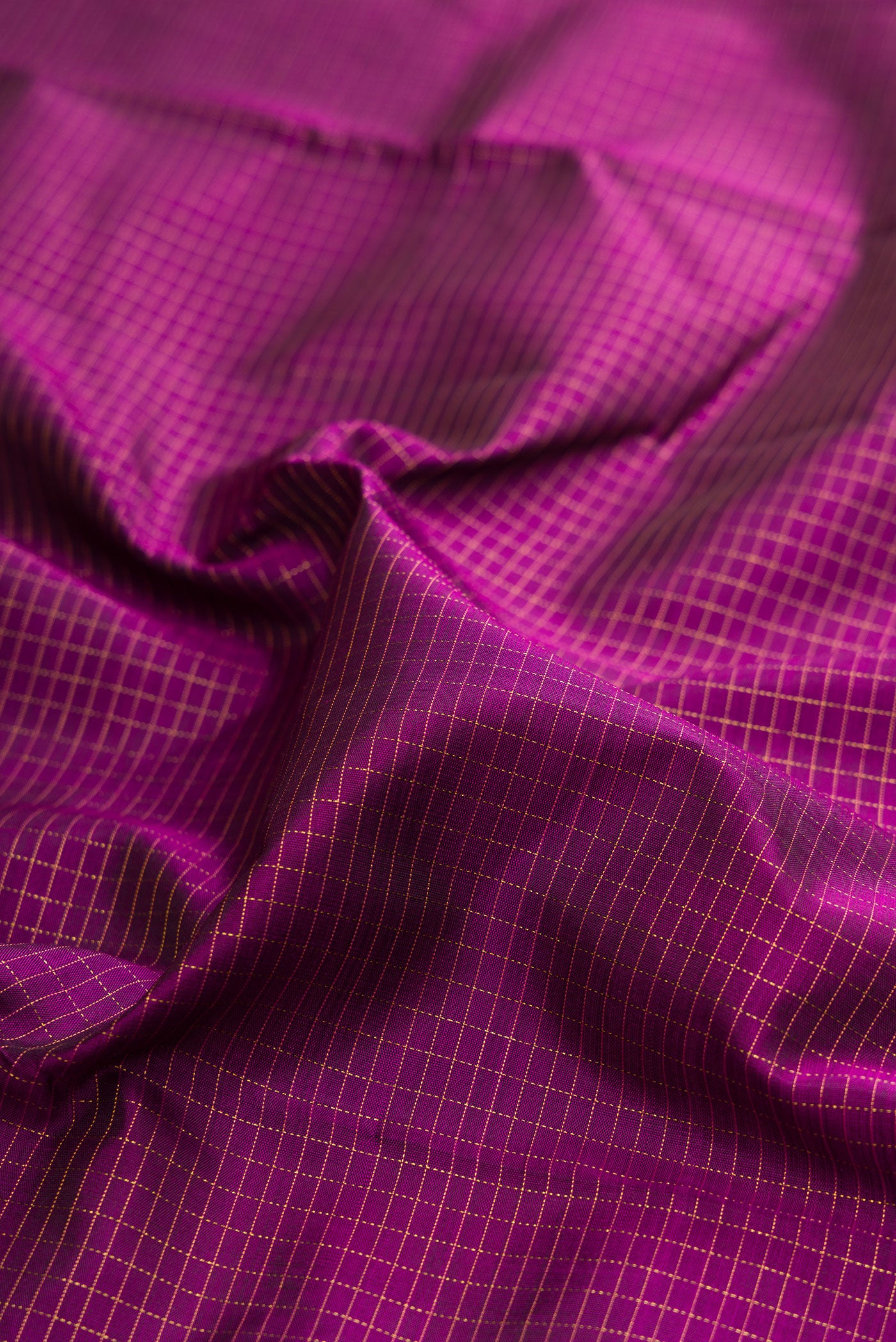 Close up of Purple Kanchipuram Silk Saree with Checked design on the body and Zari Border.  displaying folds
