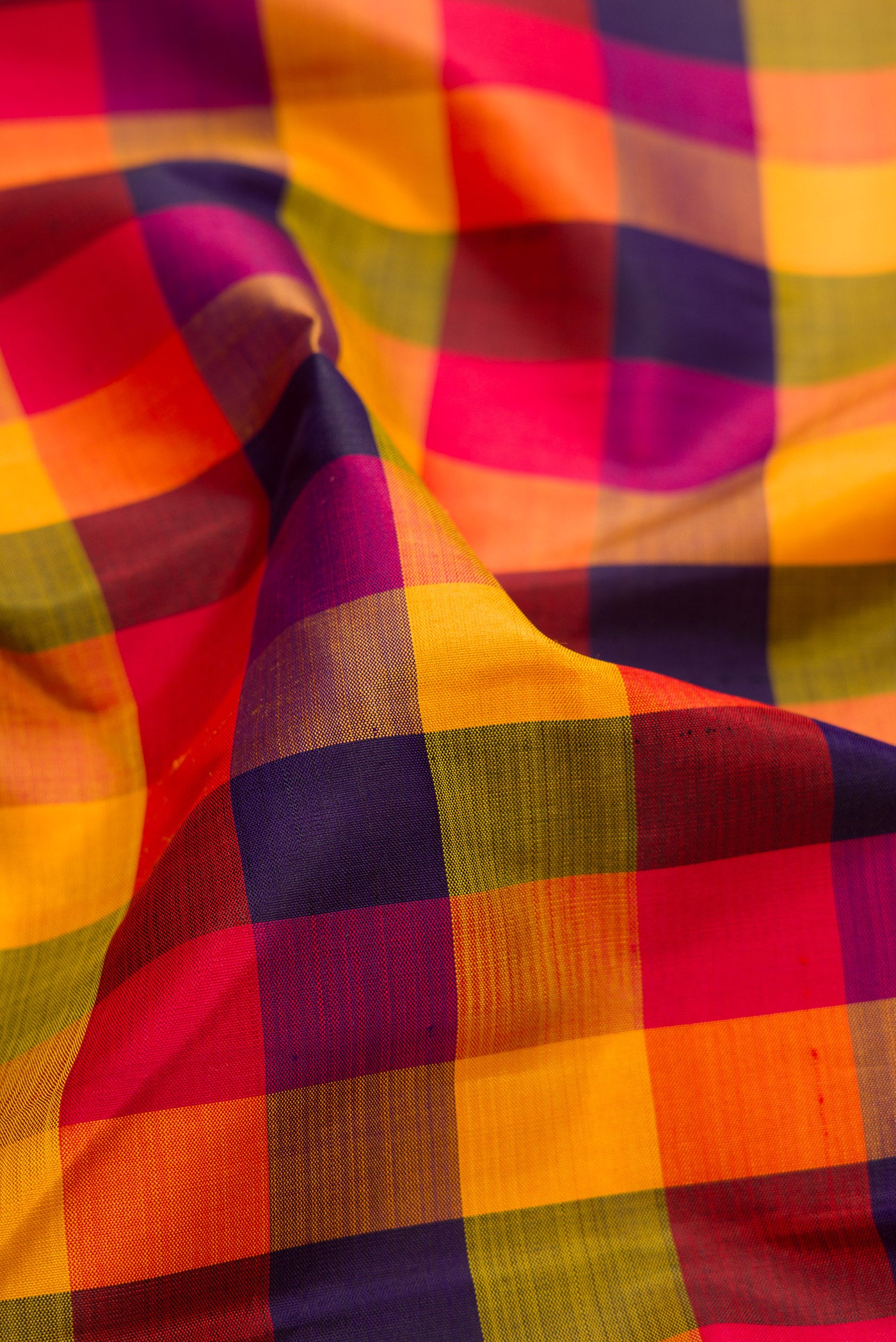 Close up of Multi Color Kanchipuram Silk Saree with Checked design on the body and Zari Border.  displaying folds