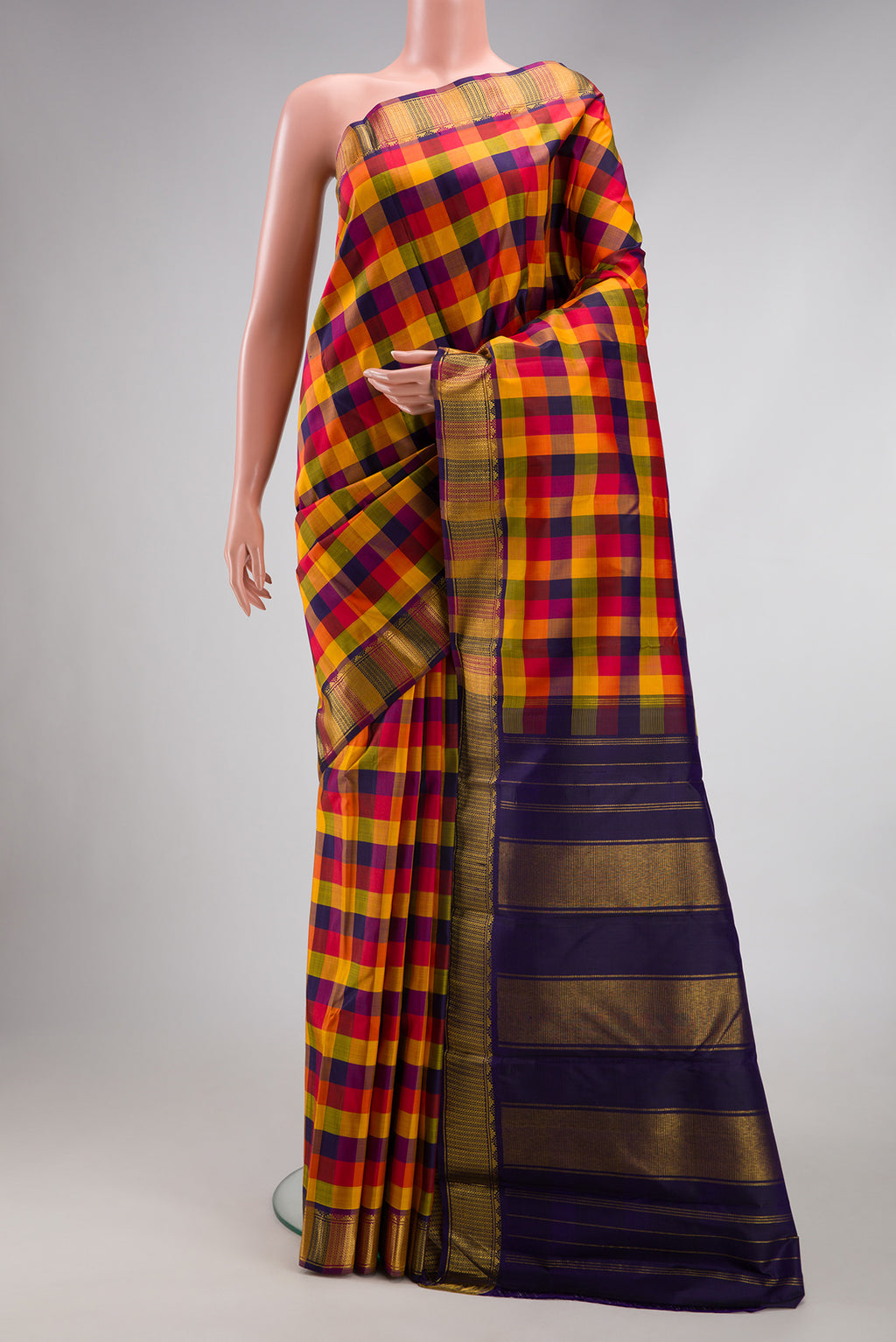 Multi Color Kanchipuram Silk Saree with Checked design on the body and Zari Border.  displayed on a mannequin