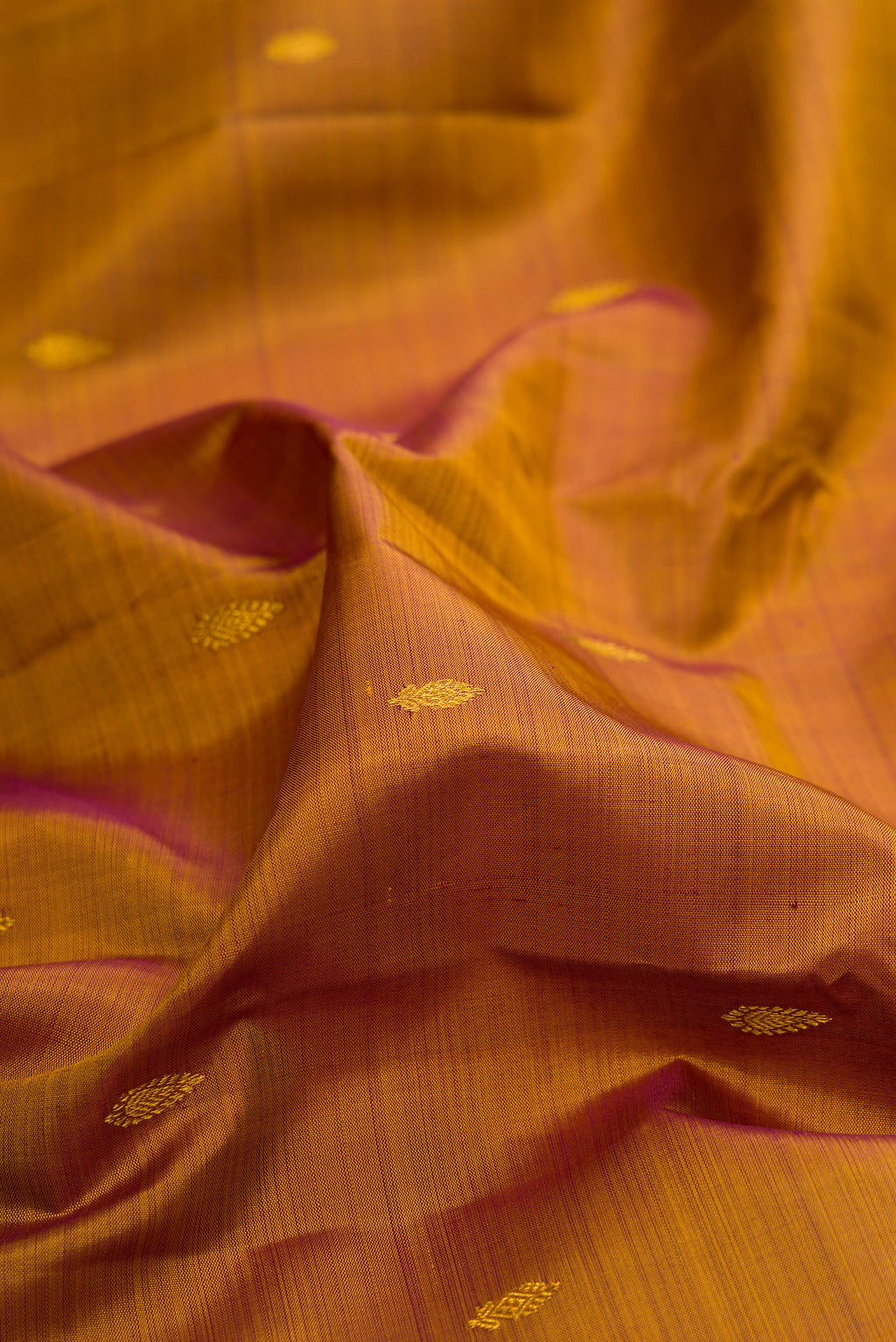 Close up of Mehandi Green Dual Tone Kanchipuram Silk Saree with Zari Butta on the body and Zari Border.  displaying folds