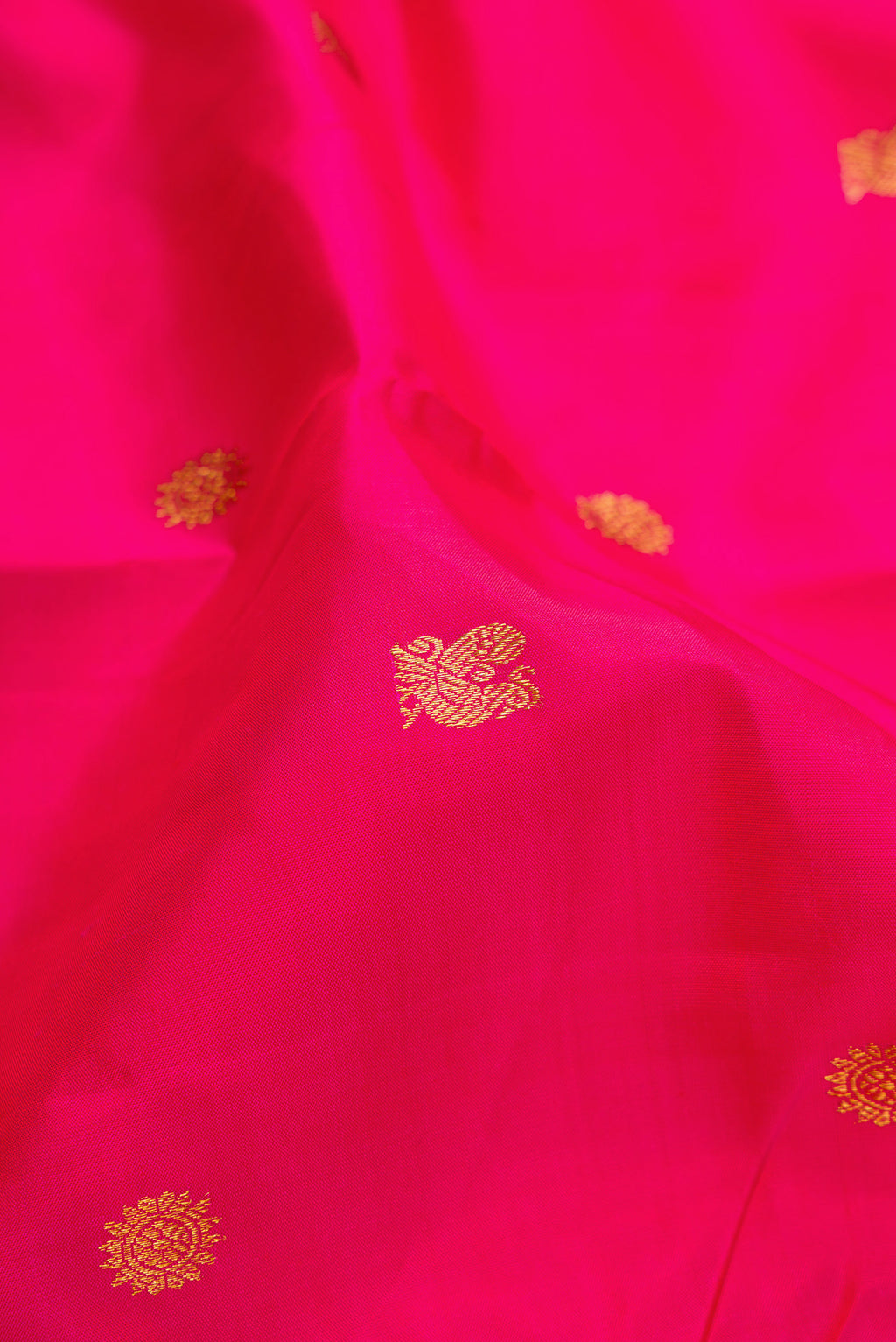 Close up of Pink Kanjivaram Silk Saree with Zari Butta on the body and Zari Border.  displaying folds