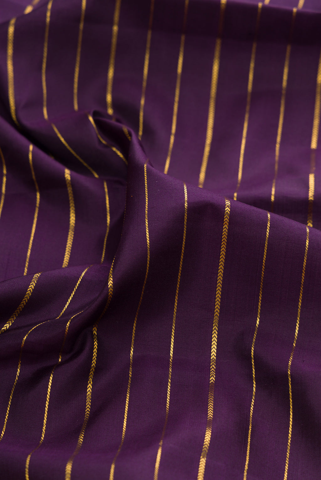 Close up of Violet Kanjivaram Silk Saree with Stripes on the body and Zari Border.  displaying folds