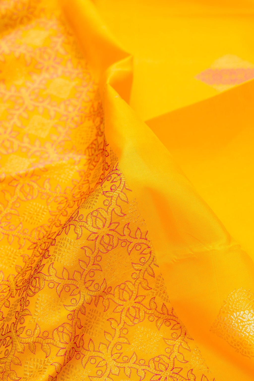 Close up of Pure Silk Yellow Kanjivaram Saree with Zari Butta on the body and Without Border.  displaying folds