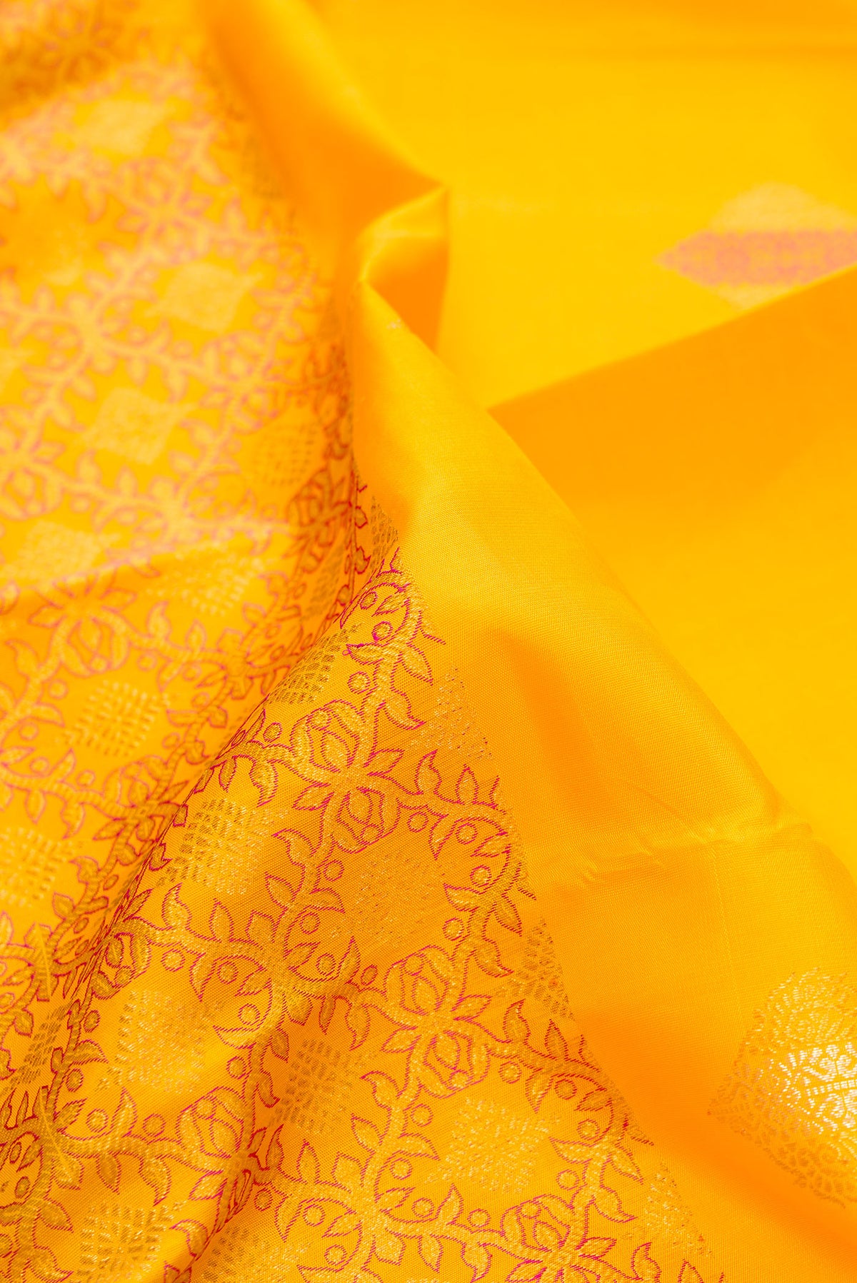 Close up of Pure Silk Yellow Kanjivaram Saree with Zari Butta on the body and Without Border.  displaying folds