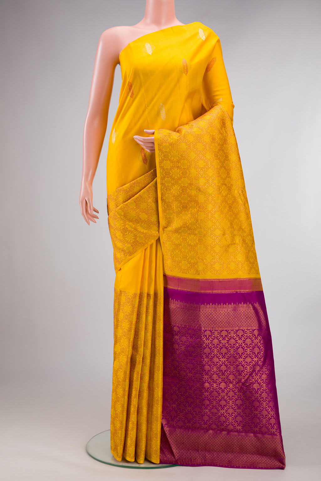 Pure Silk Yellow Kanjivaram Saree with Zari Butta on the body and Without Border.  displayed on a mannequin