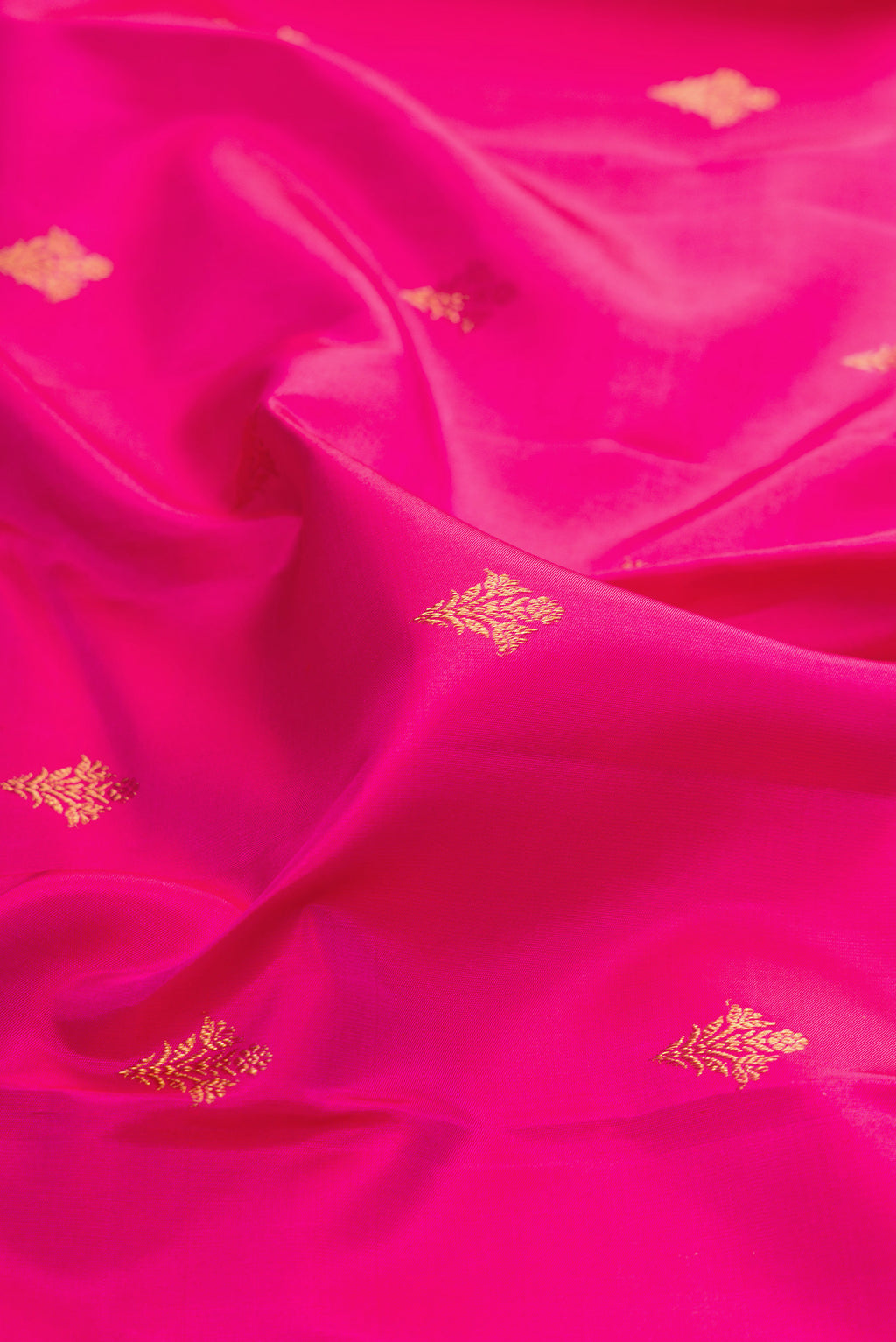 Close up of Dark Pink Kanjivaram Silk Saree with Zari Butta on the body and Fancy Border.  displaying folds