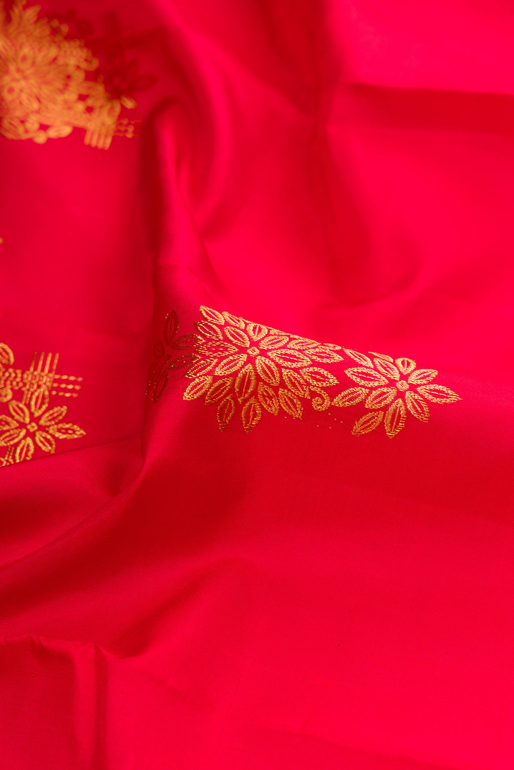 Close up of Red Kanjivaram Silk Saree with Zari Butta on the body and Fancy Border.  displaying folds