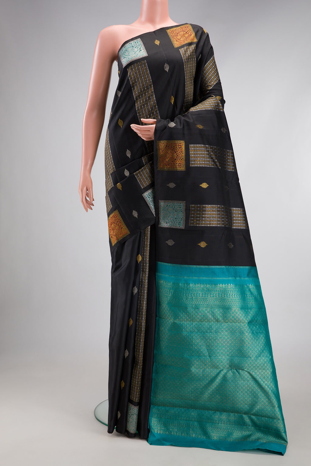 Black Kanjivaram Silk Saree with Zari Butta on the body and Without Border.  displayed on a mannequin
