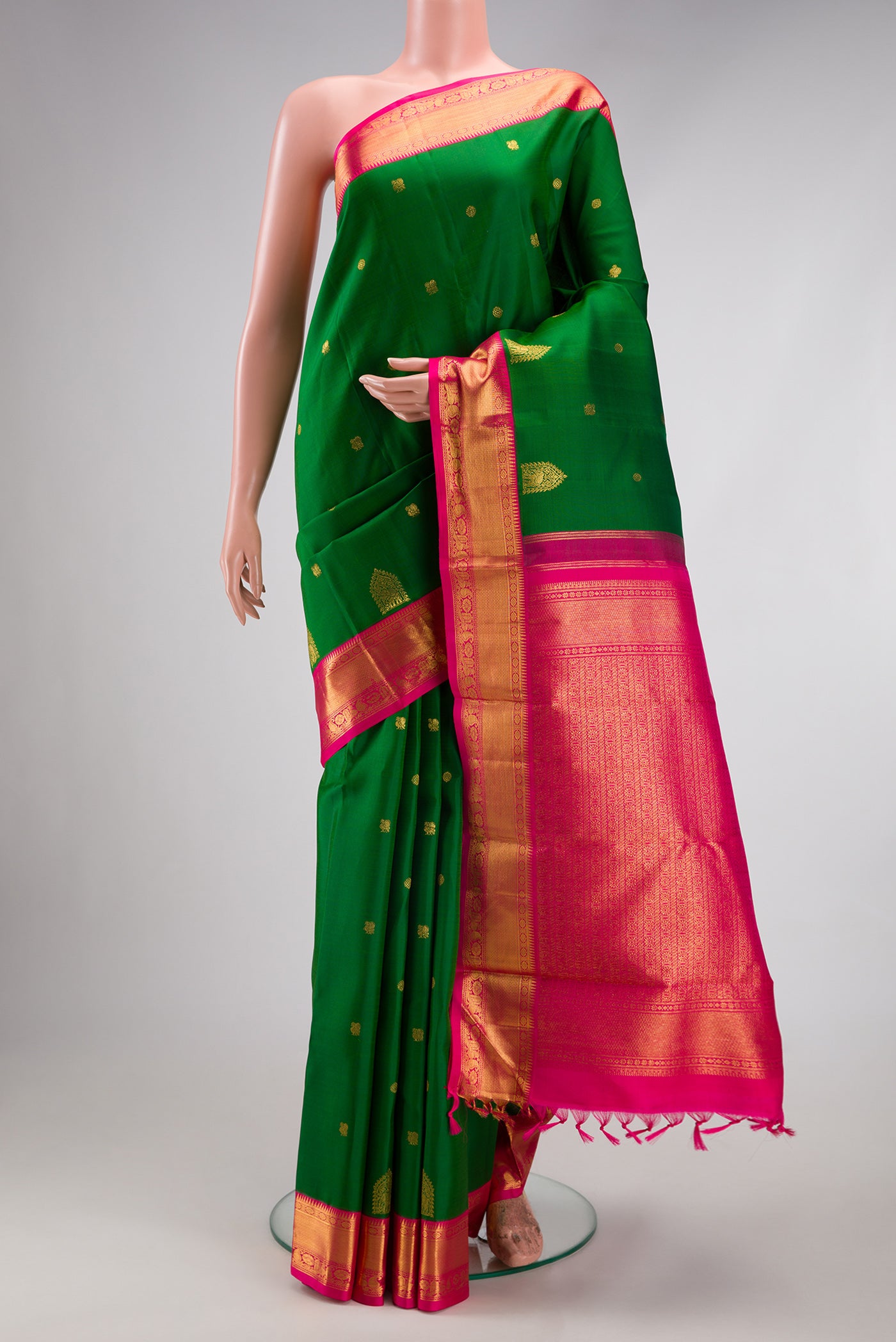 Green Kanjivaram Silk Saree with Zari Butta on the body and Zari Border.  displayed on a mannequin