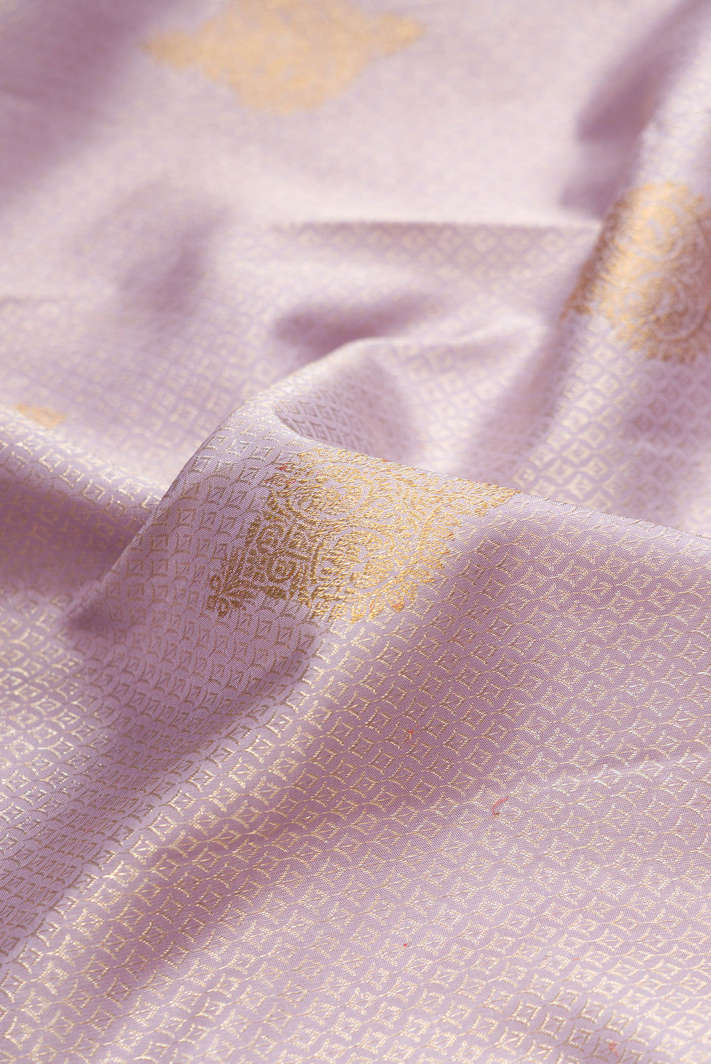 Close up of Pure Silk Lavender Kanjivaram Saree with Zari Brocade on the body and Zari Border.  displaying folds