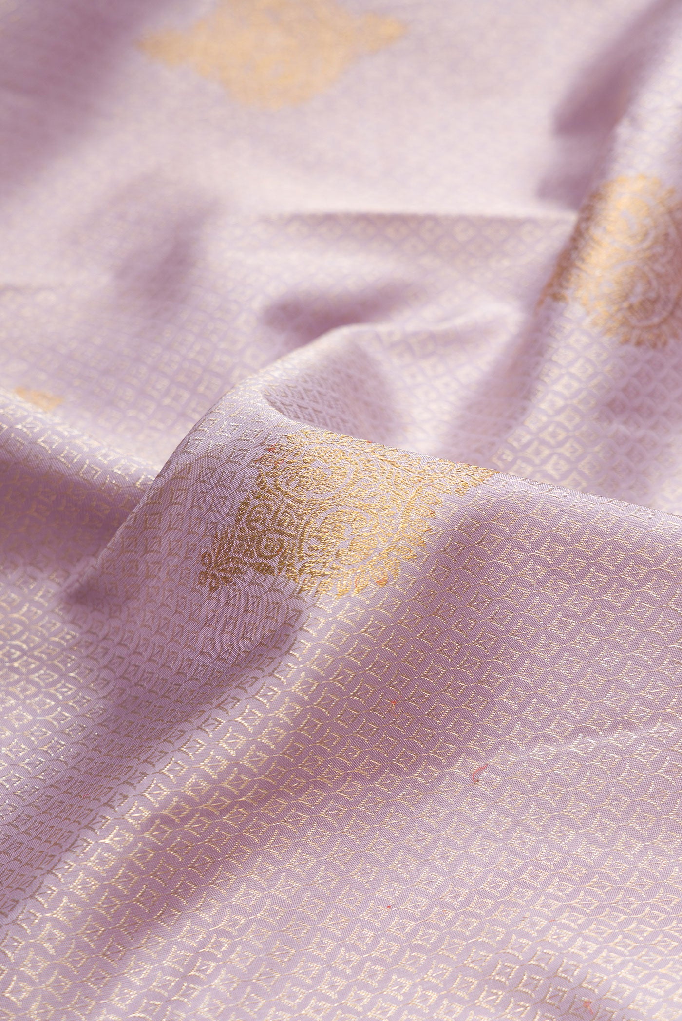 Close up of Pure Silk Lavender Kanjivaram Saree with Zari Brocade on the body and Zari Border.  displaying folds