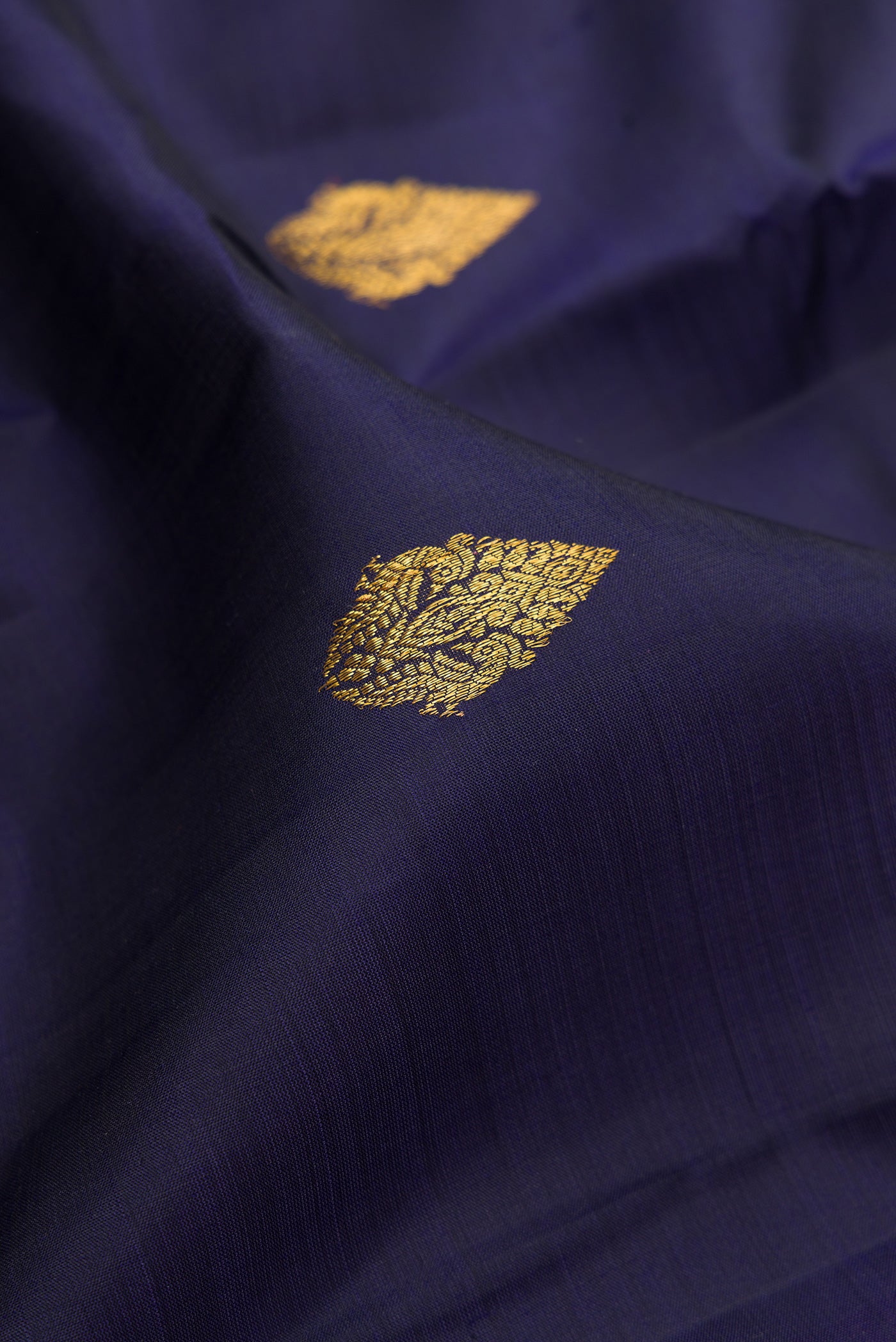 Close up of Navy Blue Kanjivaram Silk Saree with Zari Butta on the body and Fancy Border.  displaying folds