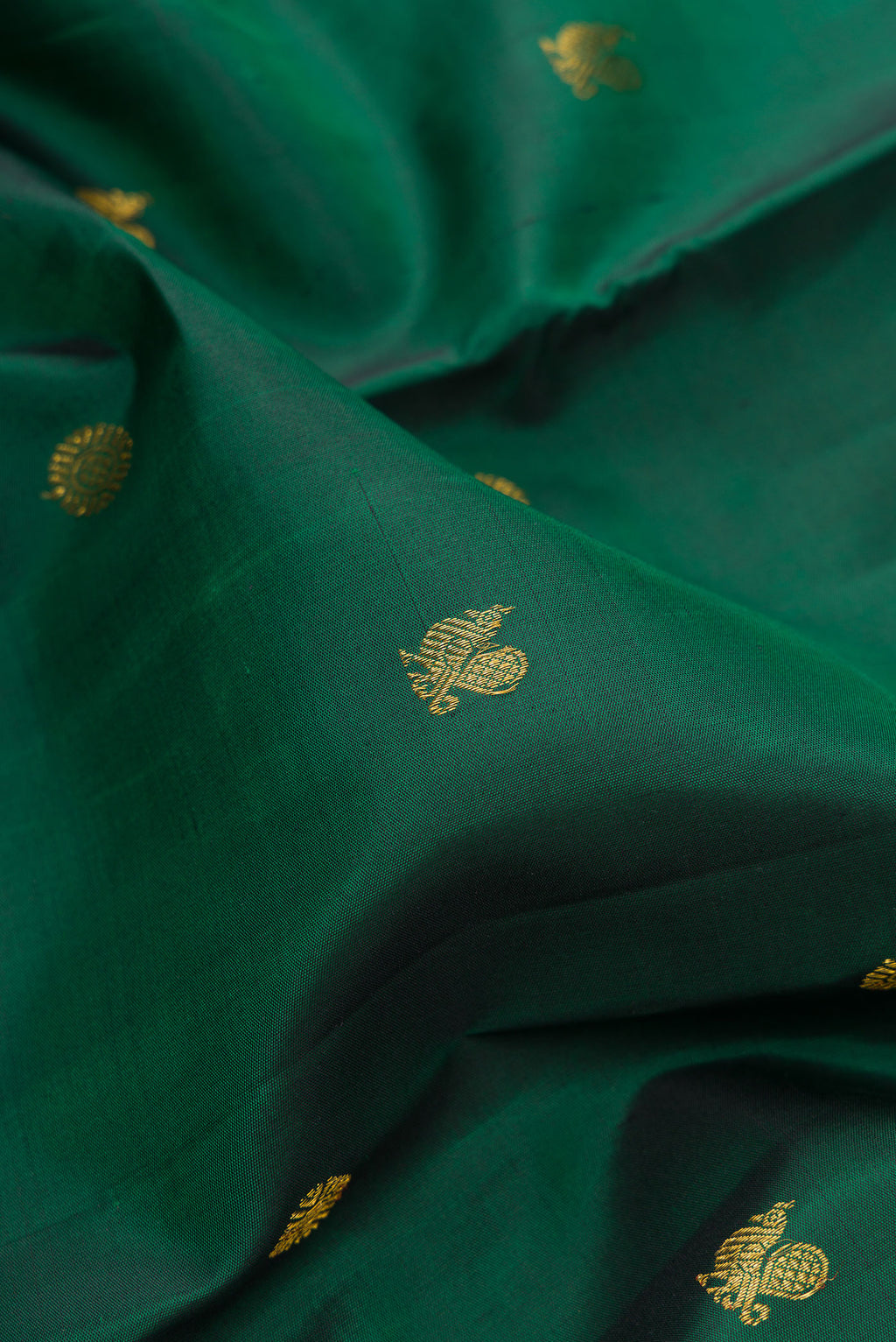 Close up of Pure Silk Bottle Green Dual Tone Kanjivaram Saree with Zari Butta on the body and Fancy Border.  displaying folds
