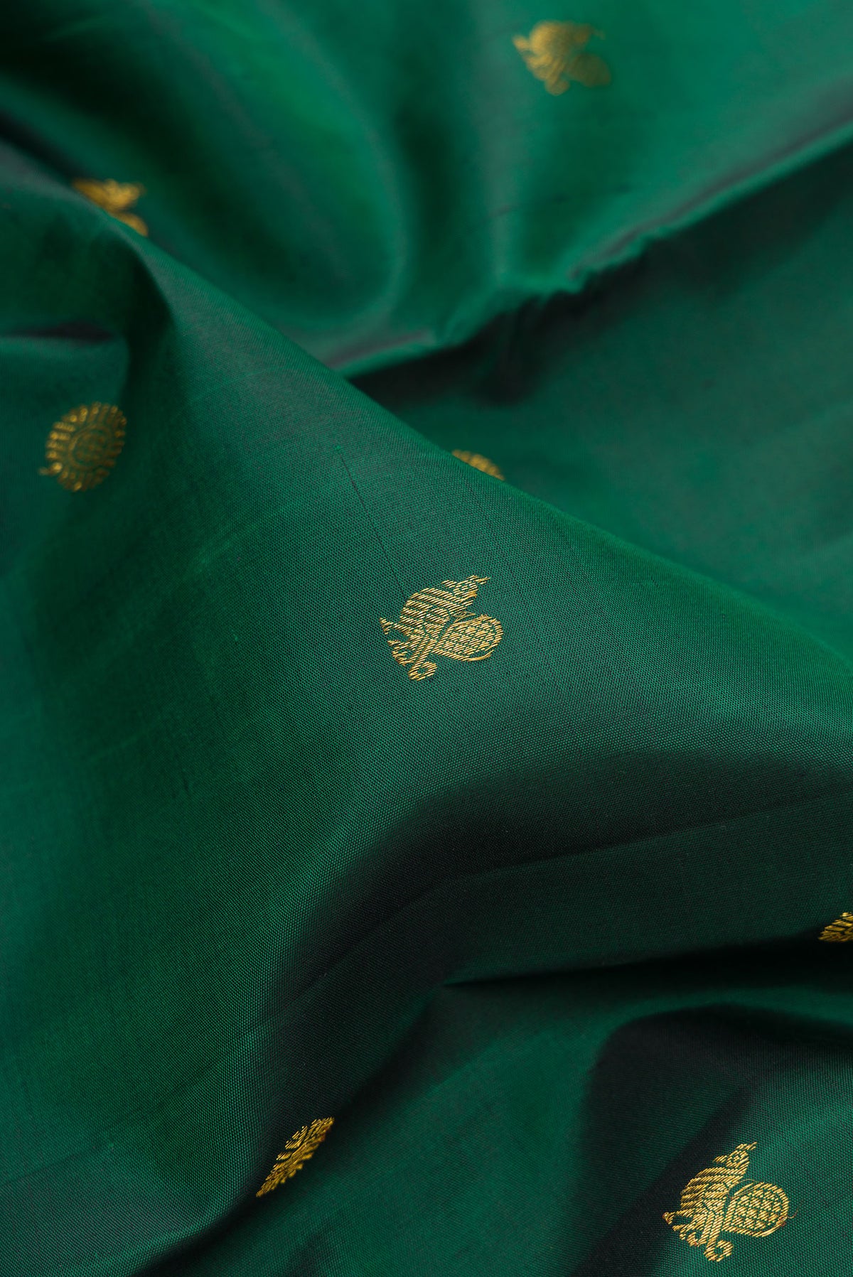 Close up of Pure Silk Bottle Green Dual Tone Kanjivaram Saree with Zari Butta on the body and Fancy Border.  displaying folds
