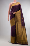 Burgundy Kanjivaram Silk Saree with Zari Butta on the body and Zari Border.  displayed on a mannequin